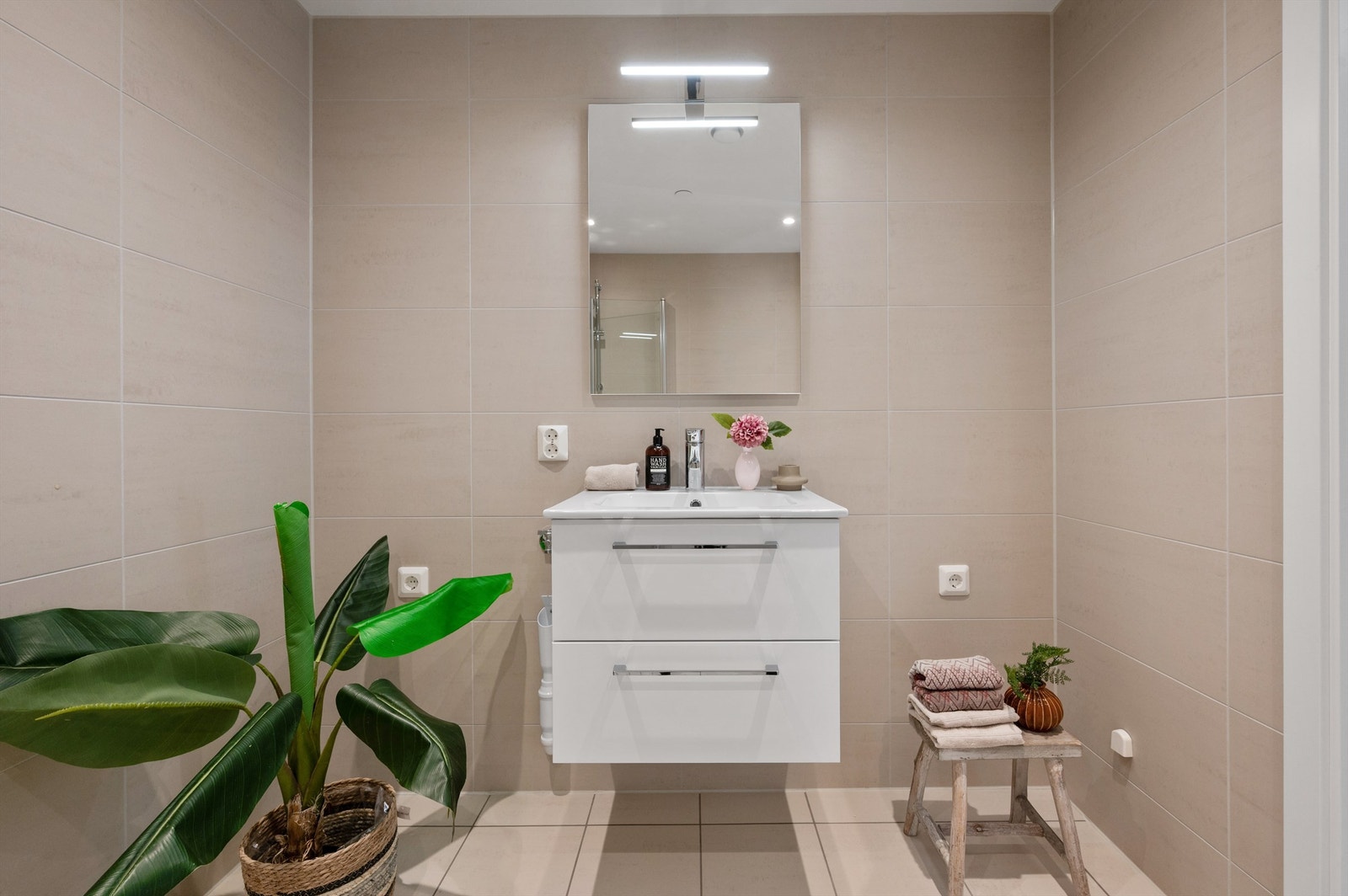 Videre har badet et romslig dusjhjørne og vegghengt klosett. Det er opplegg for vaskemaskin. Galleribilde