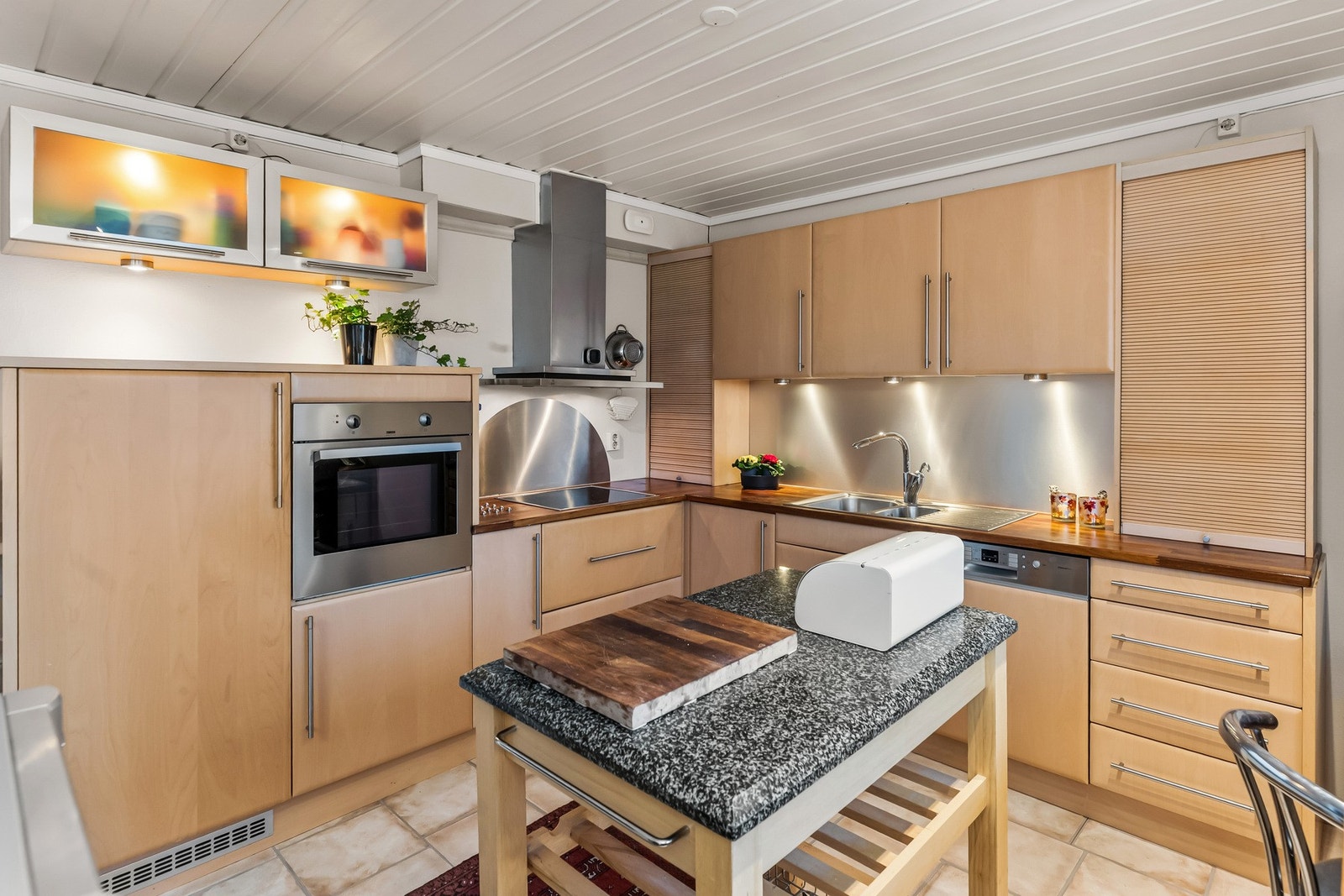 Kjøkkenet har innredning med slette fronter og benkeplate i heltre, som gir et lunt og tidløst uttrykk. Galleribilde