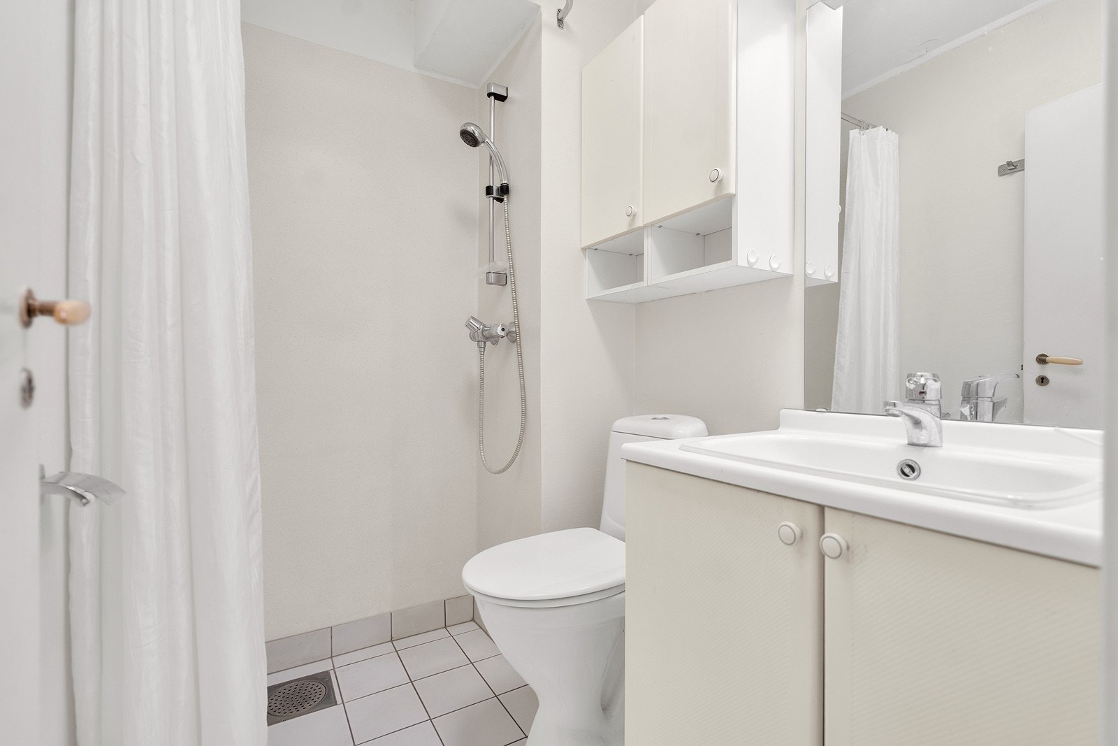 Bad med flislagte gulv og dusjnisje Galleribilde