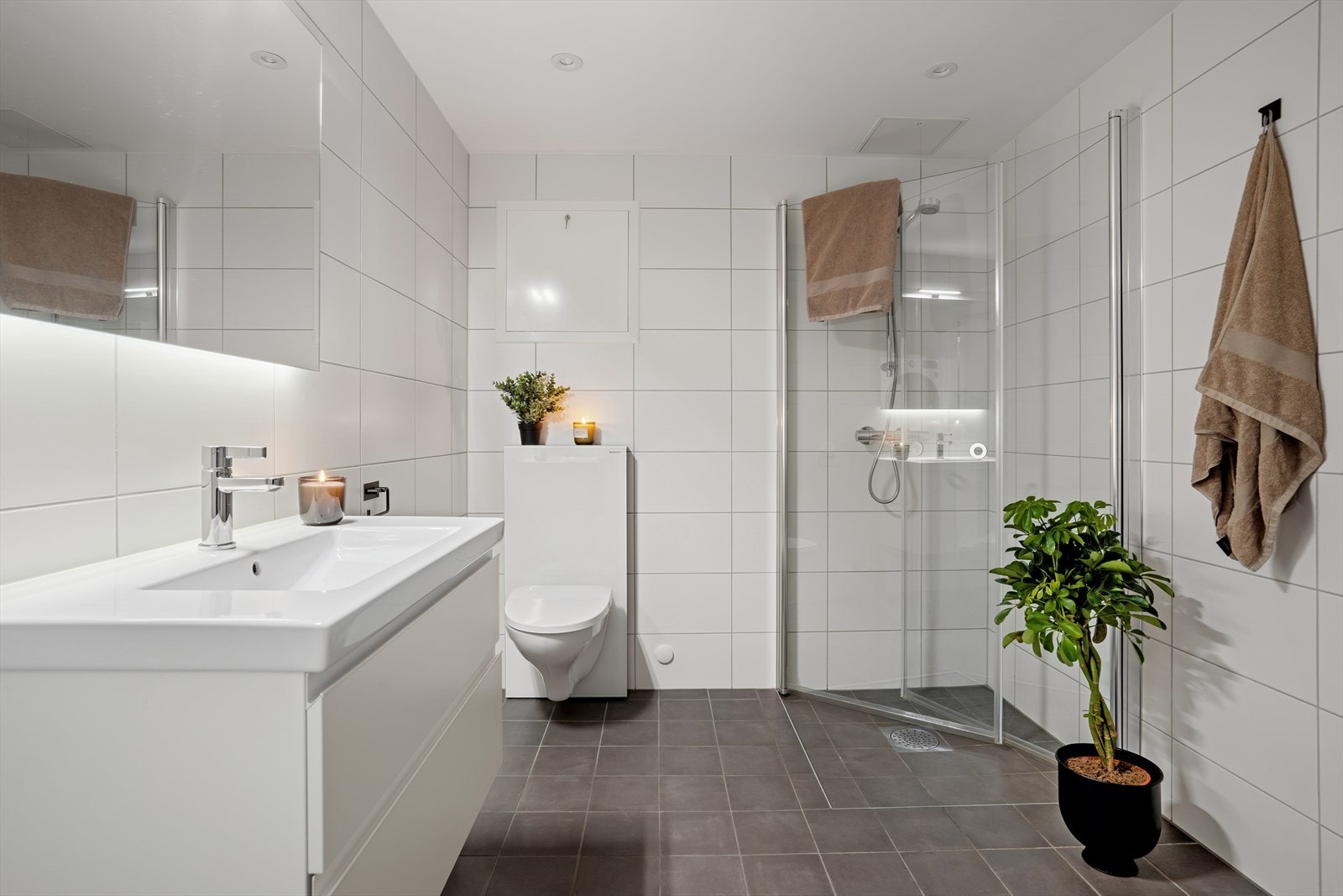 Delikat og innbydende baderom med tidløse fliser på både gulv og vegger som skaper et helhetlig og moderne uttrykk. Galleribilde