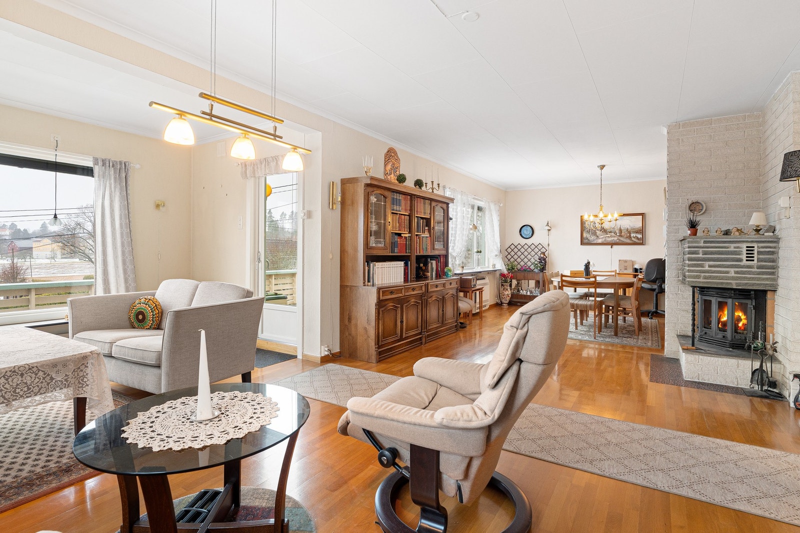 Stuen har store vinduer som gir godt med naturlig lys. Legg merke til peisen i bakgrunnen. Galleribilde