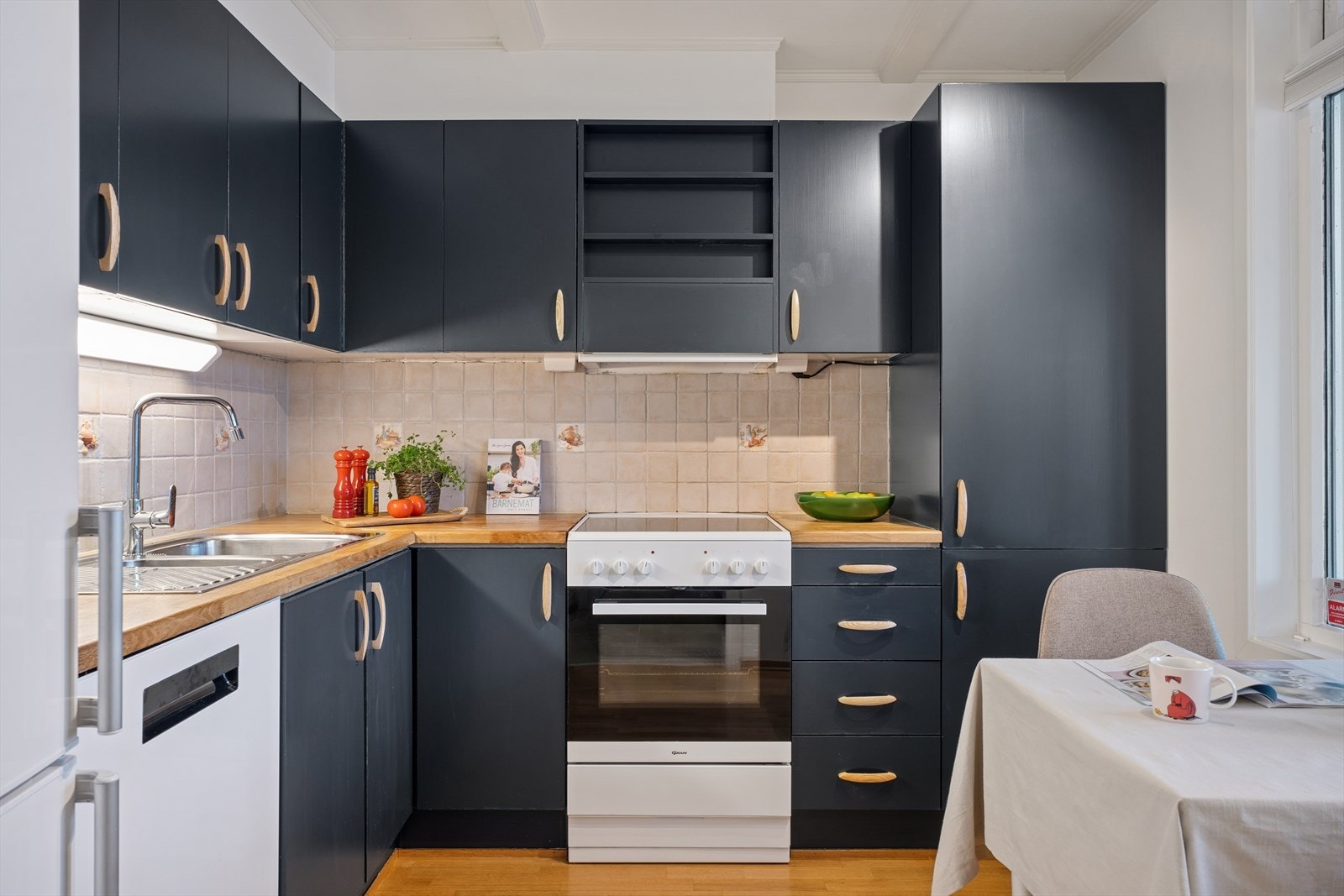 De mørke frontene kombinert med treverk gir et lunt uttrykk, og det store vinduet slipper inn rikelig med naturlig lys. Galleribilde