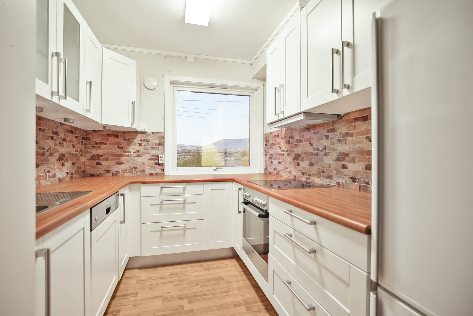 Kjøkkenet har en funksjonell utforming som sørger for effektive arbeidsflater og rikelig med skapplass. Galleribilde