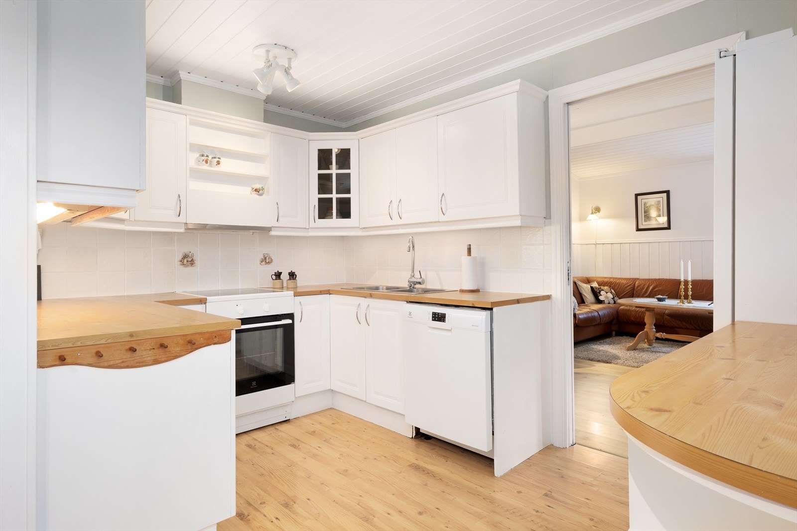 Frå stova har ein adkomst til kjøkkenet. Her har ein kjøkkeninnreiing med lyse profilierte frontar og benkeplate i laminat. Galleribilde