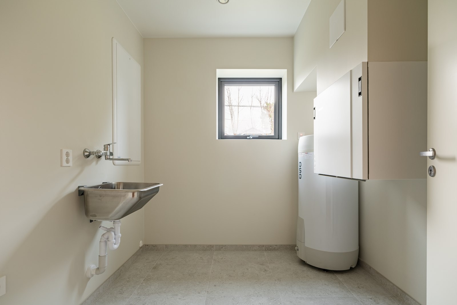 I 1. etasje er det etablert et pent vaskerom med flislagt gulv og vannbåren gulvvarme, samt malte vegger. Rommet er utstyrt med skyllekar og opplegg for både vaskemaskin og tørketrommel. Her er også varmtvannsbereder plassert. Galleribilde