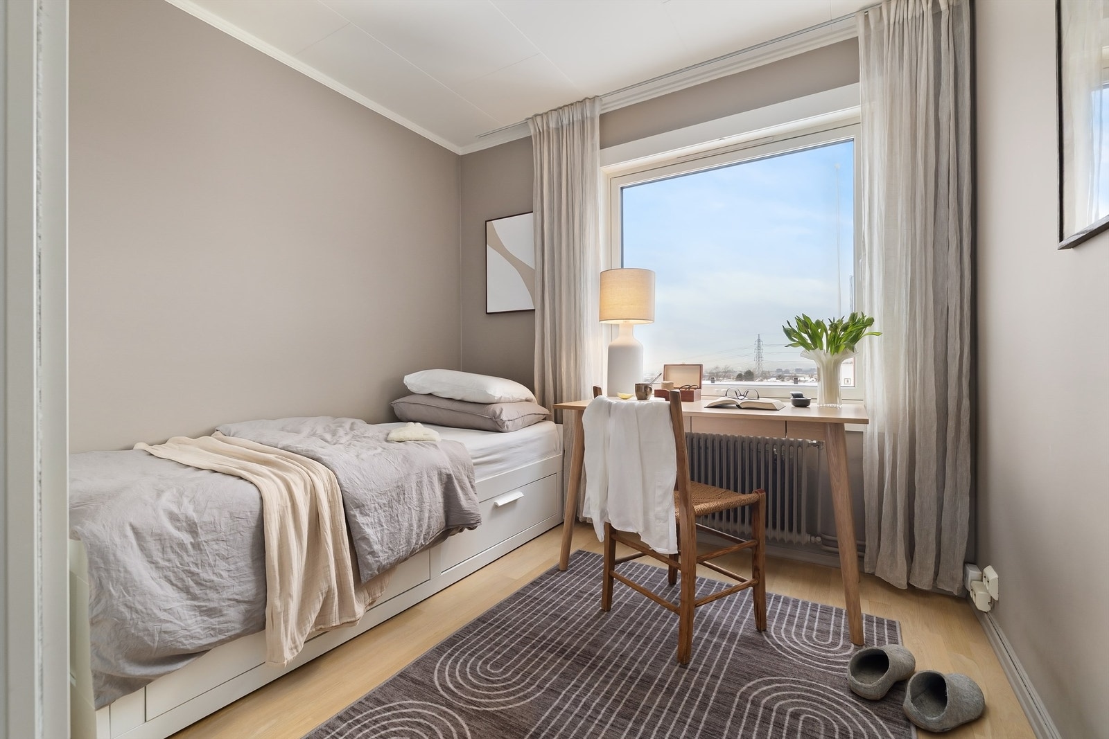 Veggflatene er malt i en lun farge og på gulvet er det klassisk, lys eikeparkett Galleribilde