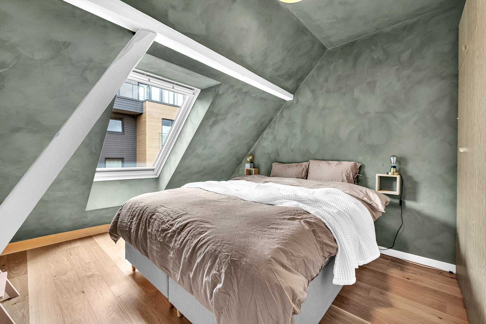 Soverommet har en rolig atmosfære med skråtak, dempede farger og godt med dagslys fra stort vindu. Den plassbygde løsningen gir rommet karakter og utnytter arealet godt. Galleribilde