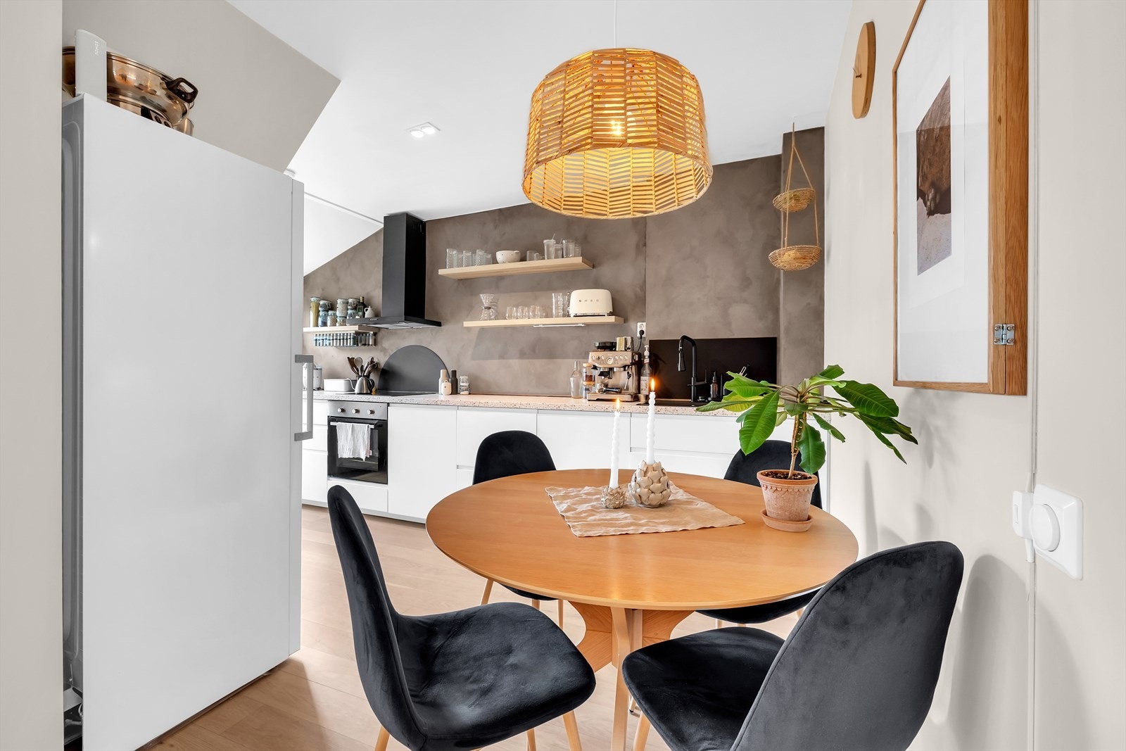 Spiseplassen er lunt plassert med nærhet til både kjøkken og oppholdsrom. Vegghengt kjøkken fra 2017 med åpne hyller og integrerte hvitevarer gir et luftig uttrykk. Galleribilde