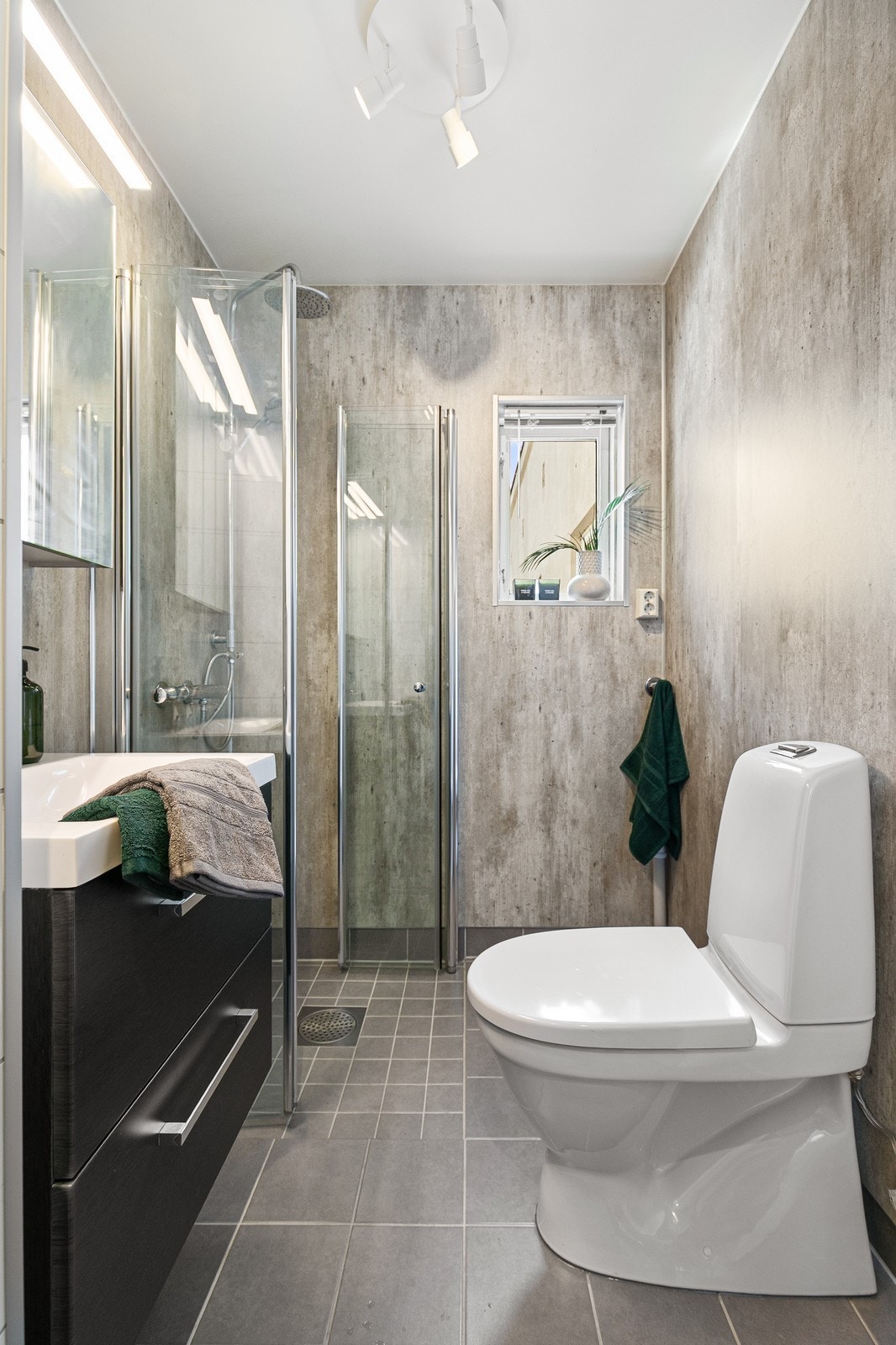 Gulvstående toalett, plass til vaskemaskin, moderne servant og dusjhjørne. Galleribilde