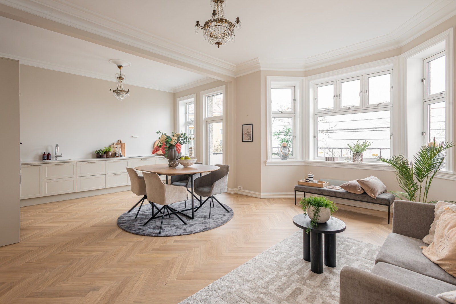 Generøs takhøyde, nydelige lyslinjer, fiskebensparkett, rosett i taket og delikate farger skaper en herlig atmosfære i stuen. Galleribilde