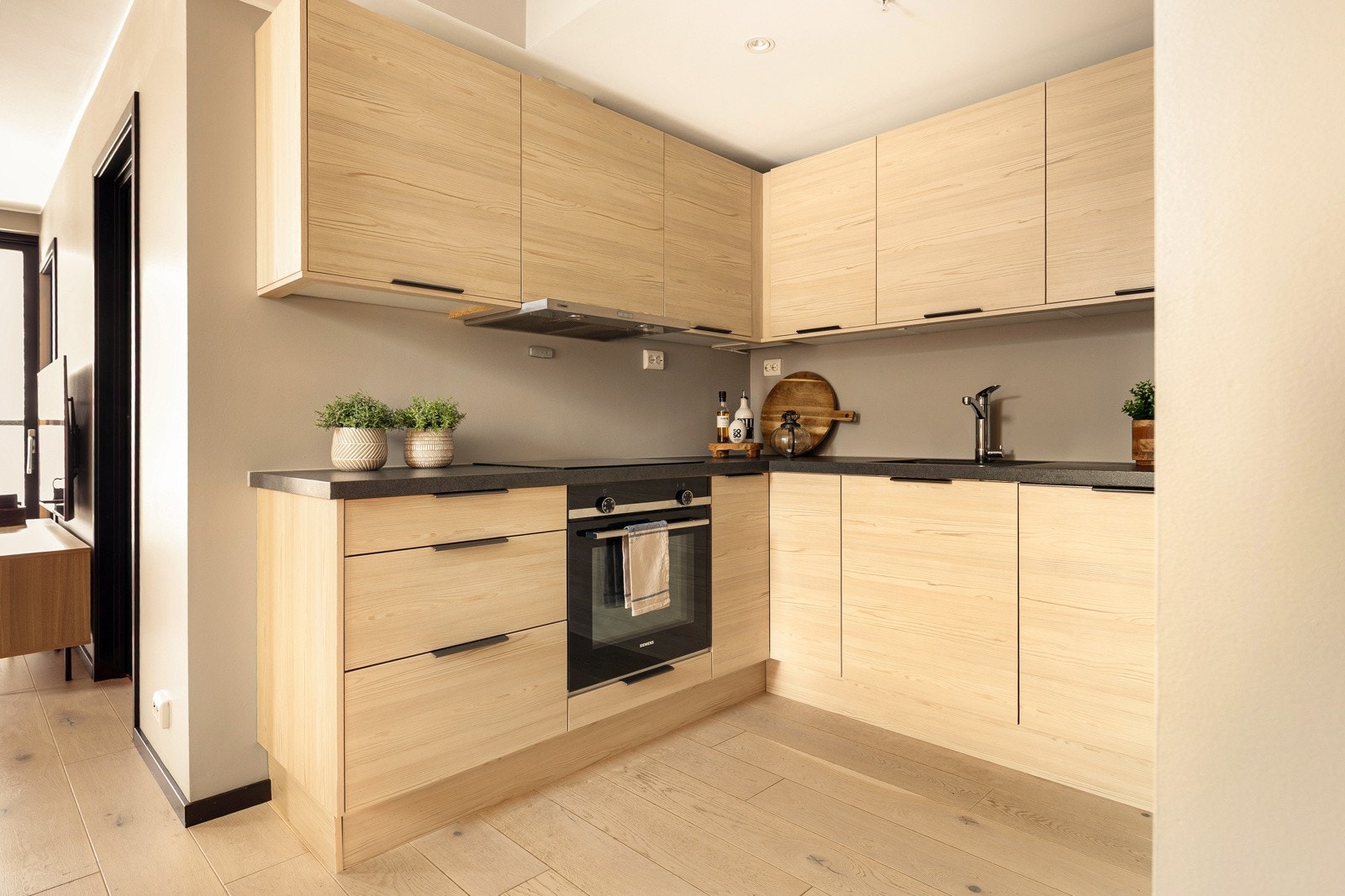 Lekkert kjøkken med innredning fra Sigdal - innredningen har glatte fronter og benkeplate er av laminat Galleribilde