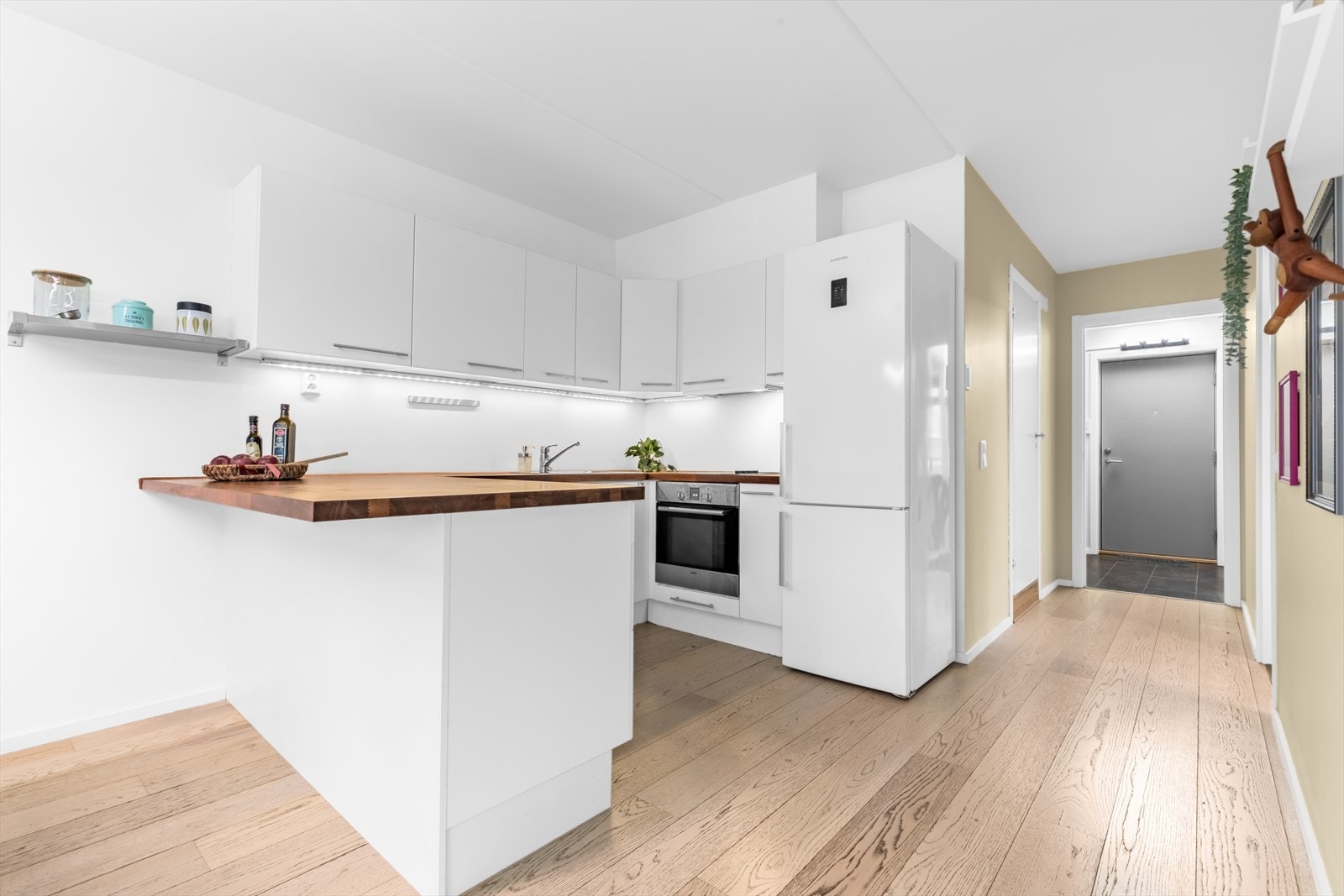 Kjøkkeninnredning og integrerte hvitevarer fra byggeåret, som er montert i åpen løsning med stuen. Galleribilde