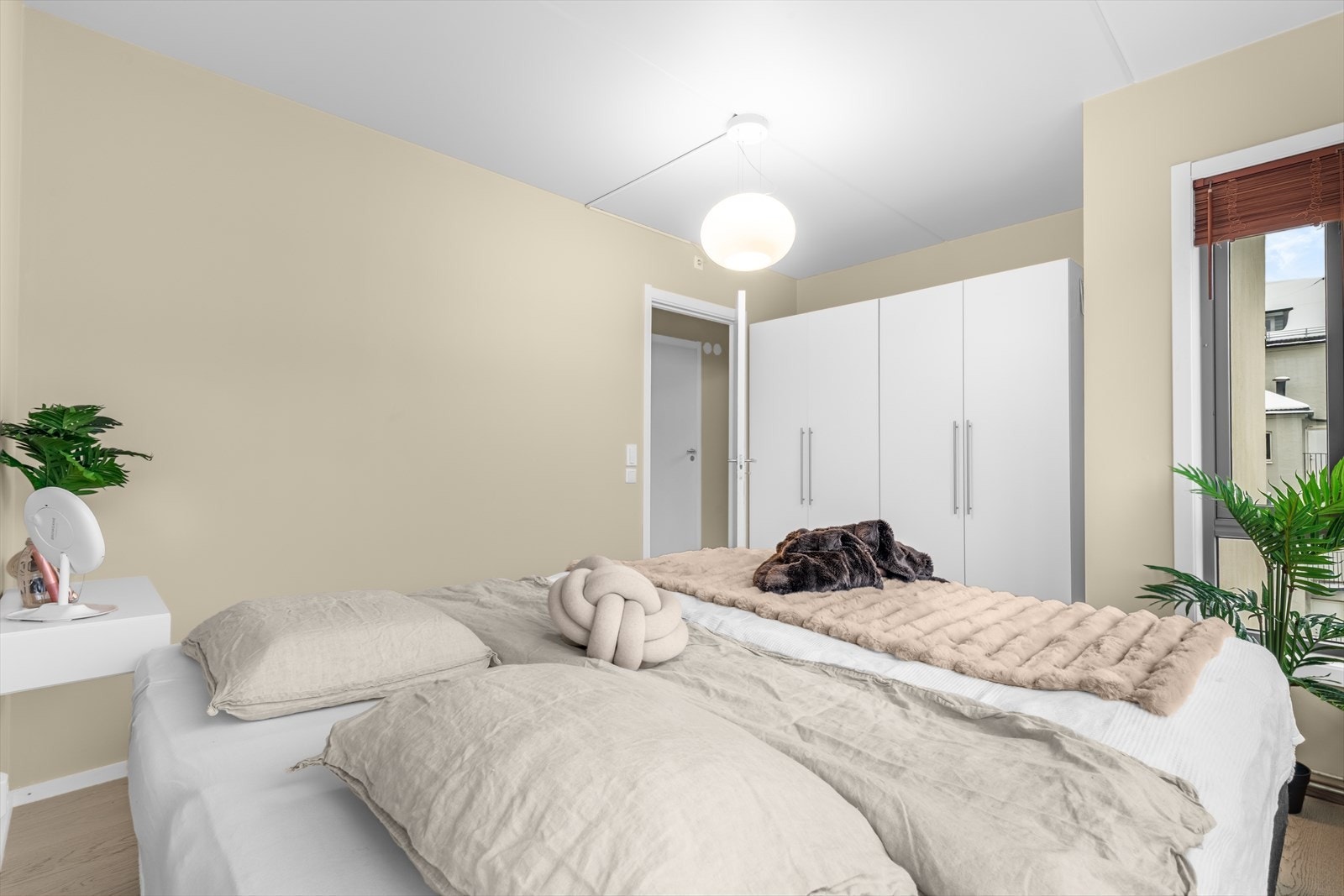 Et lyst og behagelig hovedsoverom med beige vegger som gir rommet varme og ro. Galleribilde