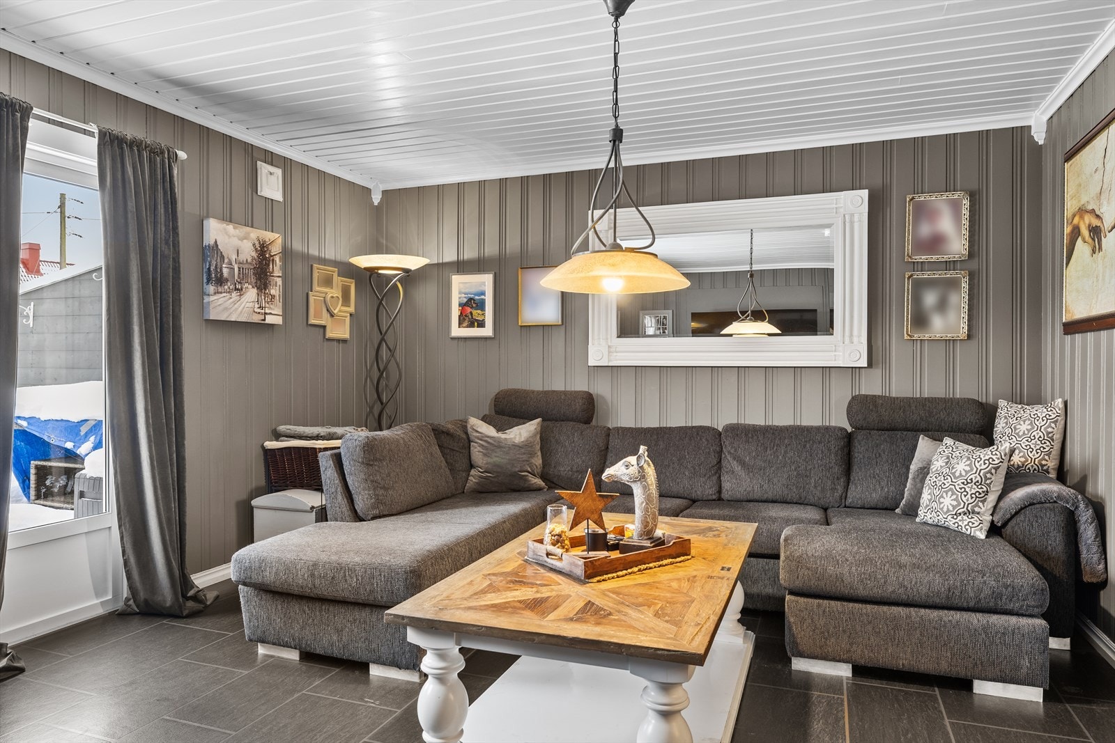 Plass til en stor sofa og dekor gir et komfortabelt oppholdsrom. Galleribilde