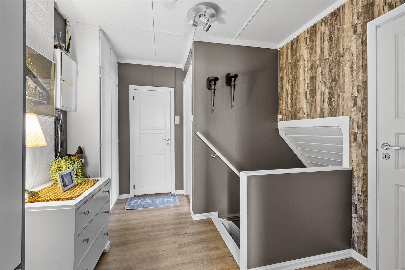 Gulv av laminat og vegger med tapet gir en solid innredning i gangen. Galleribilde