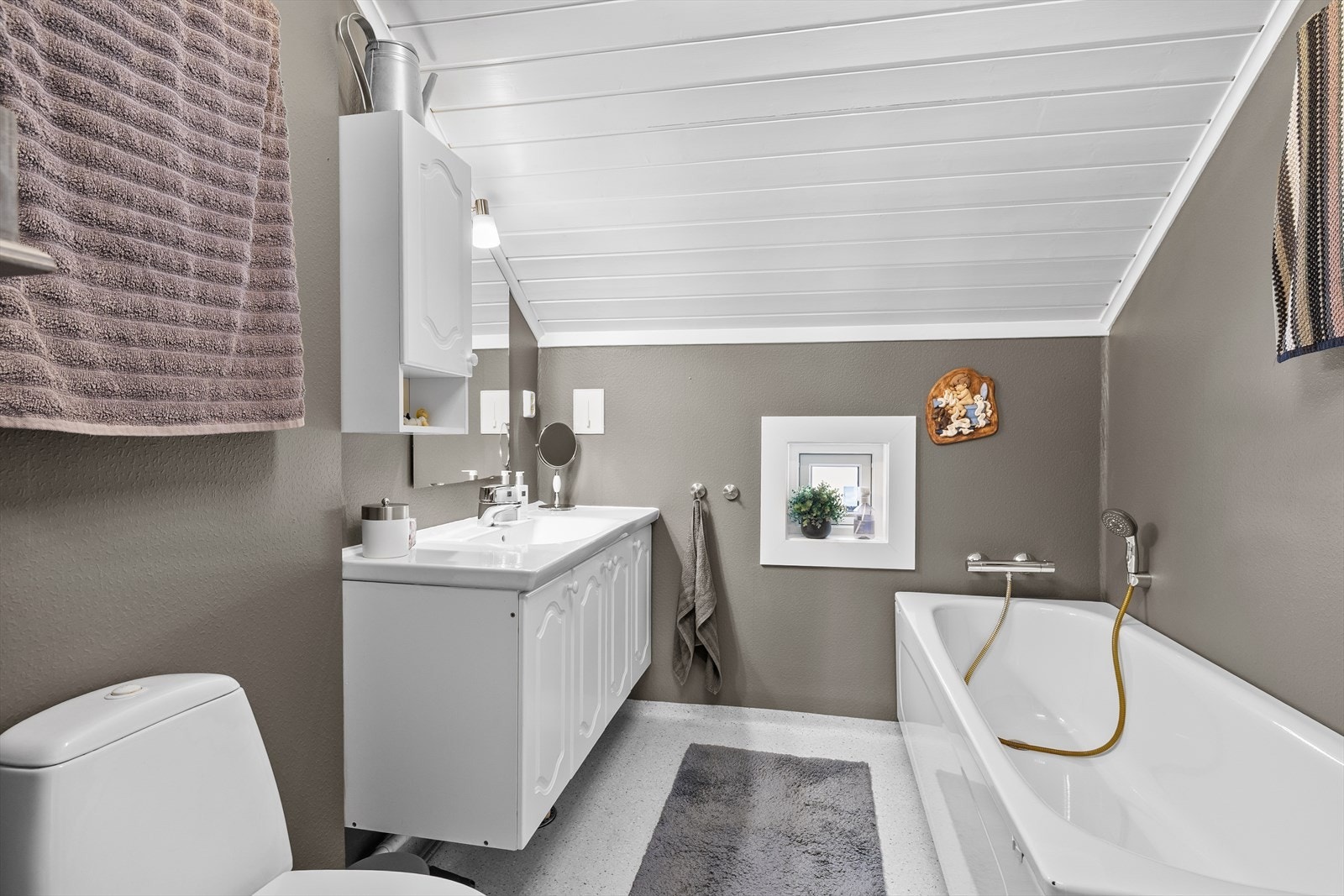 Badet har gulvbelegg, malt tapet på vegg og malt panel i tak. Galleribilde