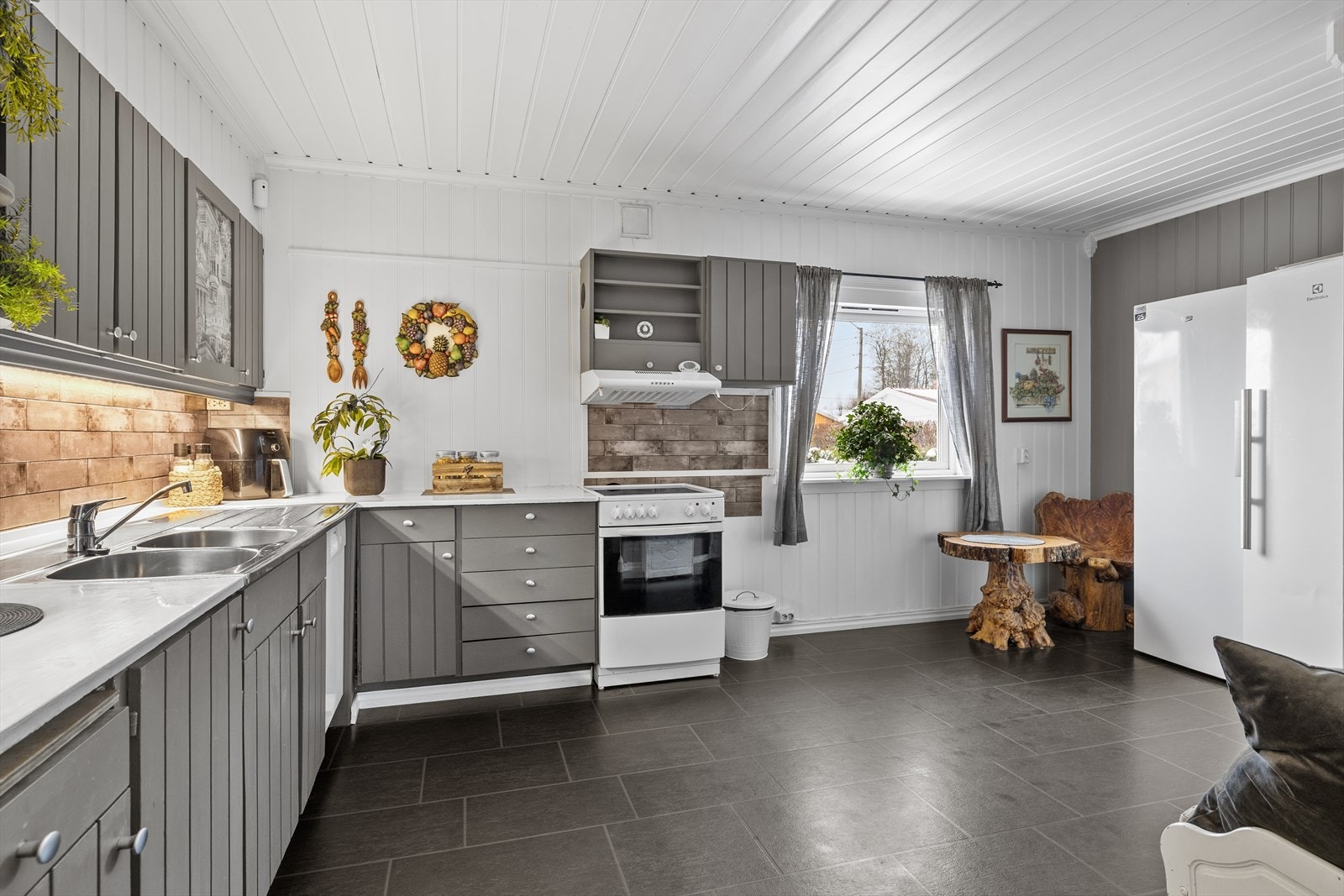 Kjøkkenet har mørke gulvfliser som gir en praktisk og lettstelt overflate. Galleribilde