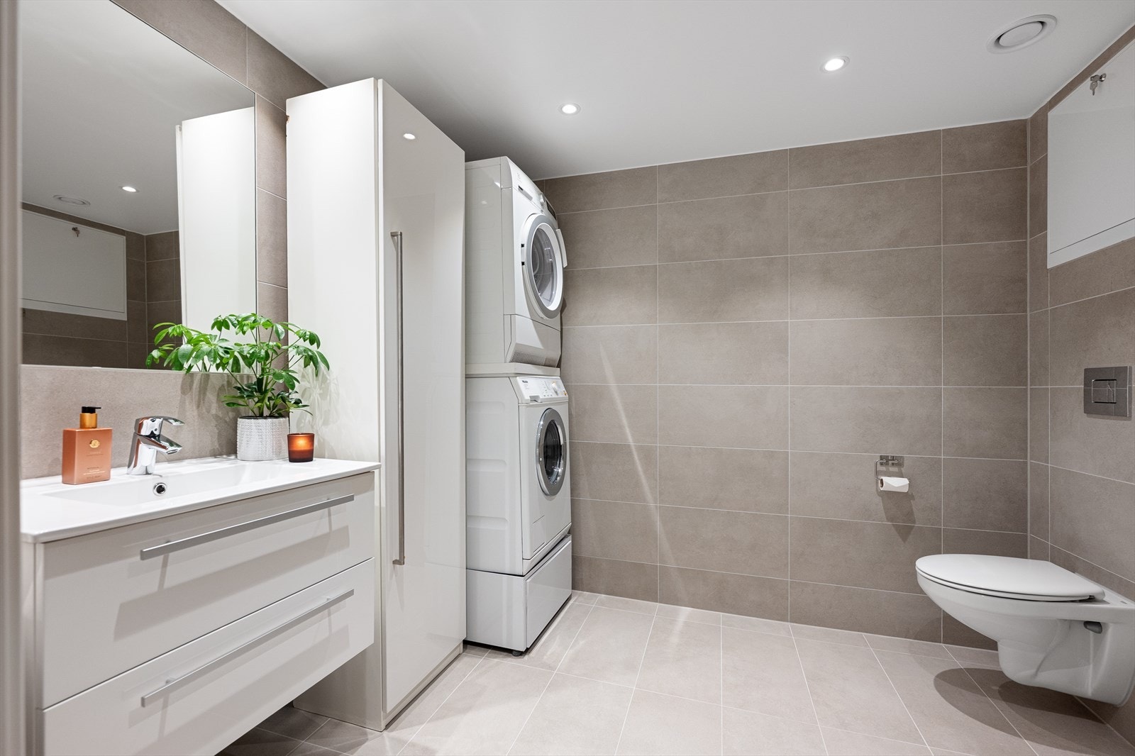 Leilighetens andre bad er romslig og har et praktisk opplegg for vaskemaskin og tørketrommel. Galleribilde