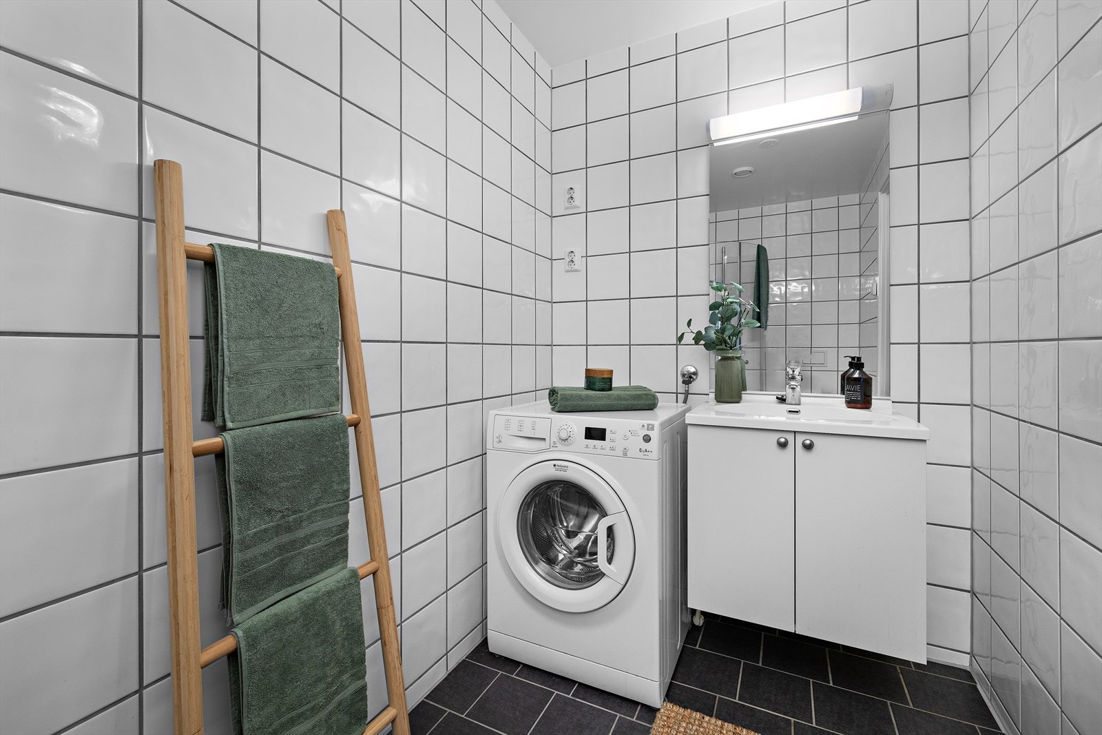 Flislagt bad med vannbåren gulvvarme og praktisk opplegg for vaskemaskin. Galleribilde