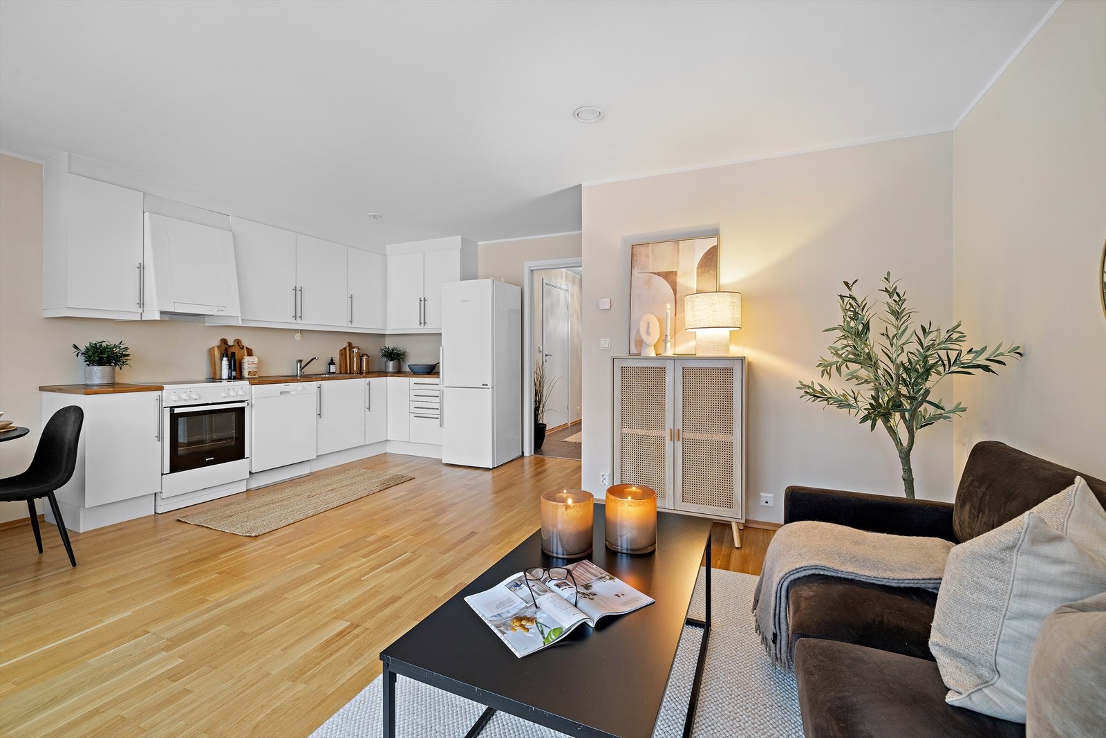 Leiligheten har en åpen stue- og kjøkkenløsning som utgjør boligens sosiale sone. Galleribilde