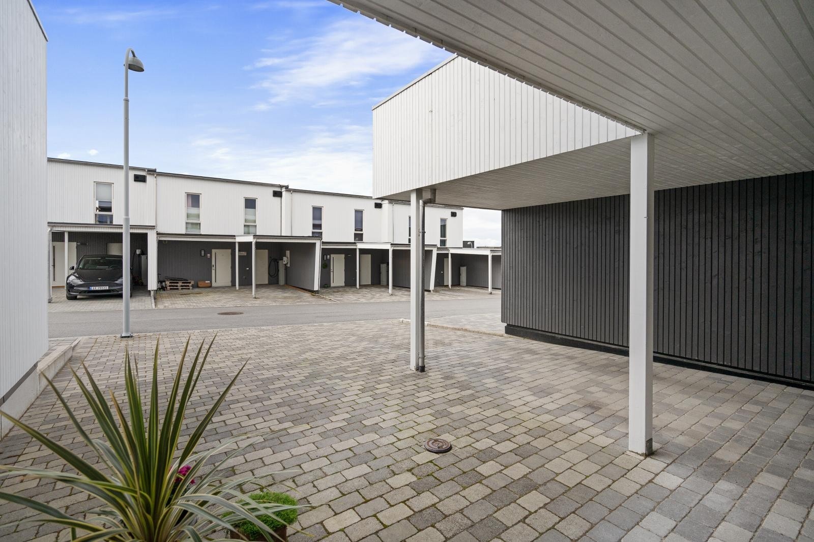 Carport med montert EL-bil lader og ellers god plass for parkering i gårdsrom. Galleribilde