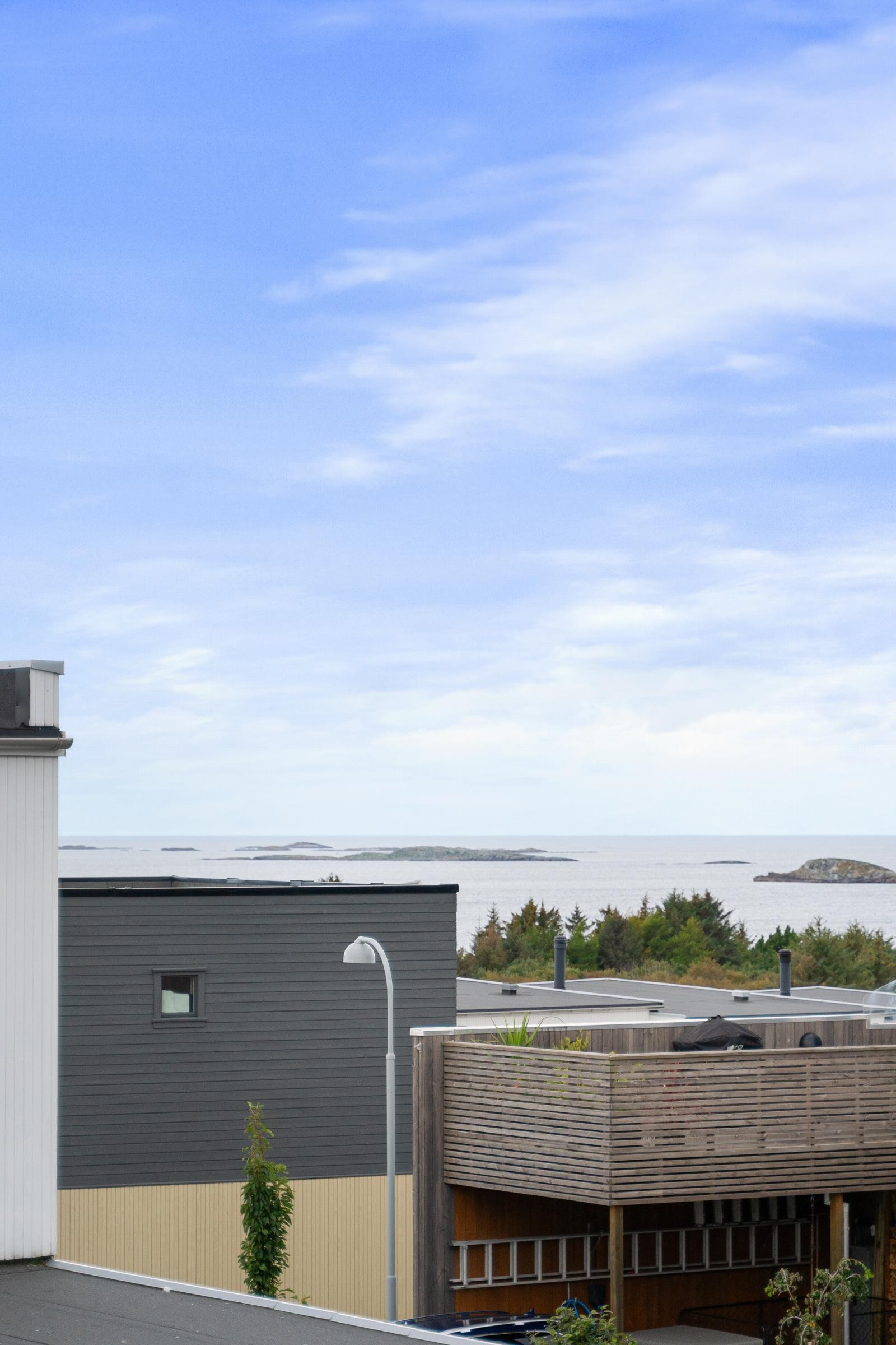 Fra balkongen ser man mot sjøen. Nabolaget byr på kort vei til herlige turstier langs sjø og natur. Galleribilde