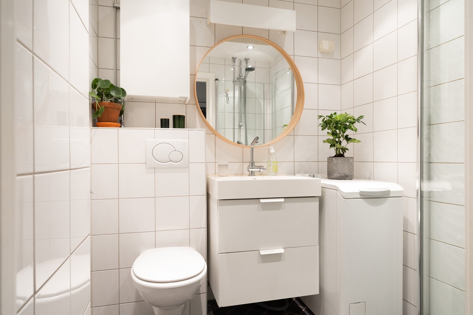 Badet består av veggmontert wc, dusjplass, servant og opplegg for vaskemaskin. Galleribilde