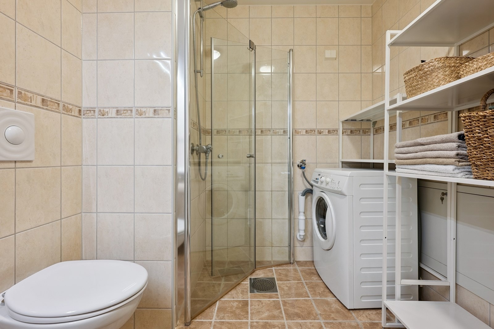 Badet er helfliset og har vegghengt toalett og dusjhjørne med nye (2024) innfellbare glassdører. Galleribilde