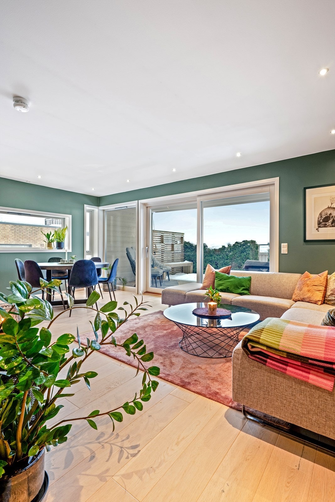 Store skyvedører i glass åpner opp mot uteplassen og slipper inn rikelig med dagslys. Galleribilde