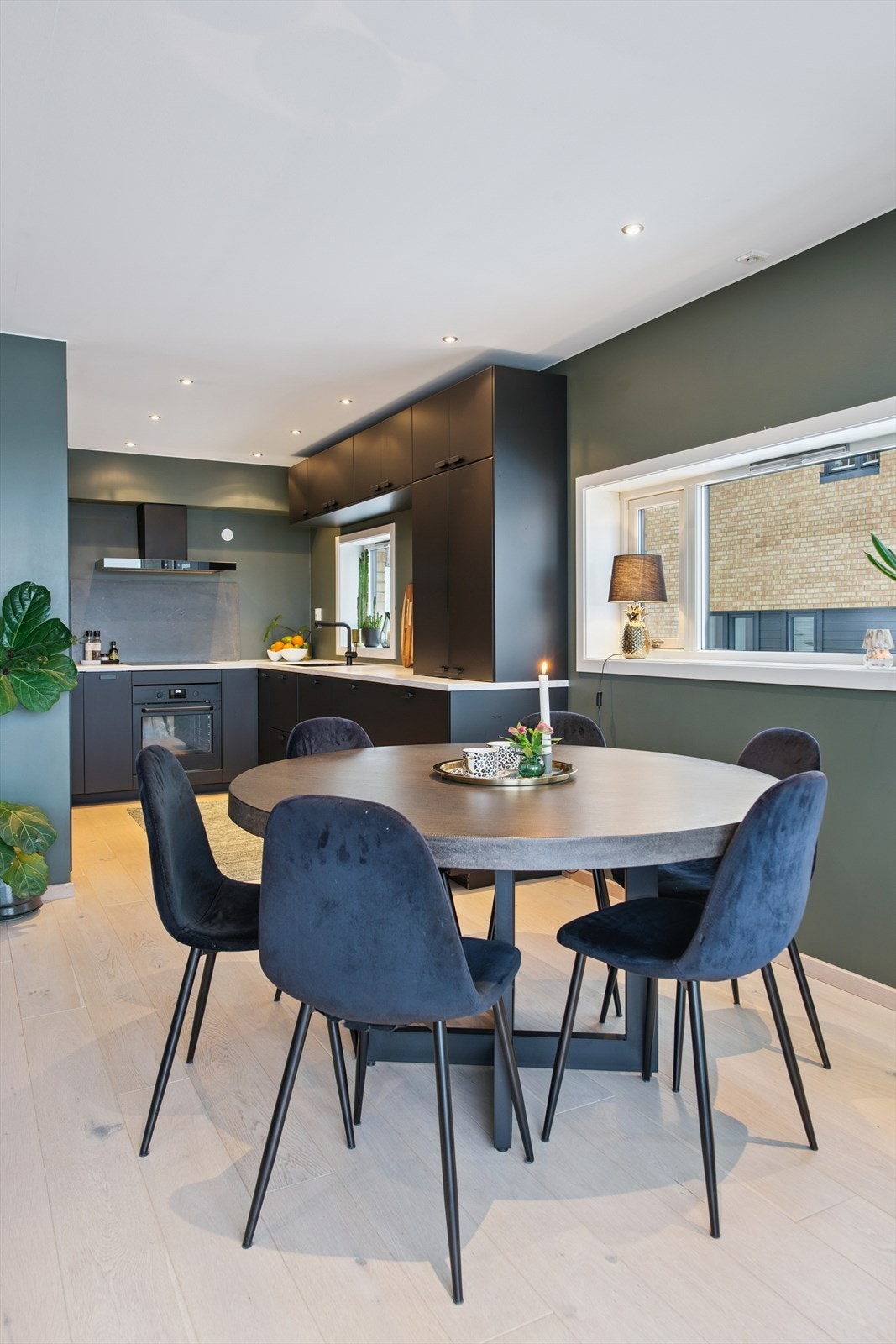 Stilren kjøkkeninnredning med mørke, slette fronter og rikelig med skapplass. Galleribilde