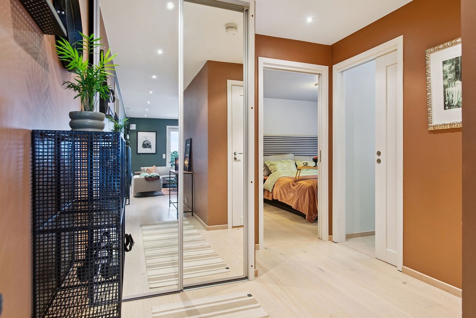 En romslig skyvedørsgarderobe med speilfronter gir rikelig med oppbevaringsplass. Galleribilde