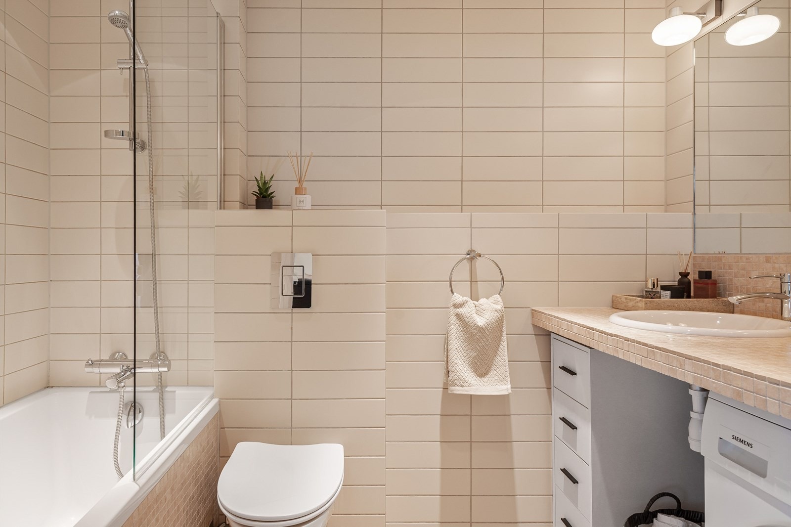 Delikat flislagt bad med gulvvarme og downlights. Badet har opplegg for vaskemaskin. Galleribilde