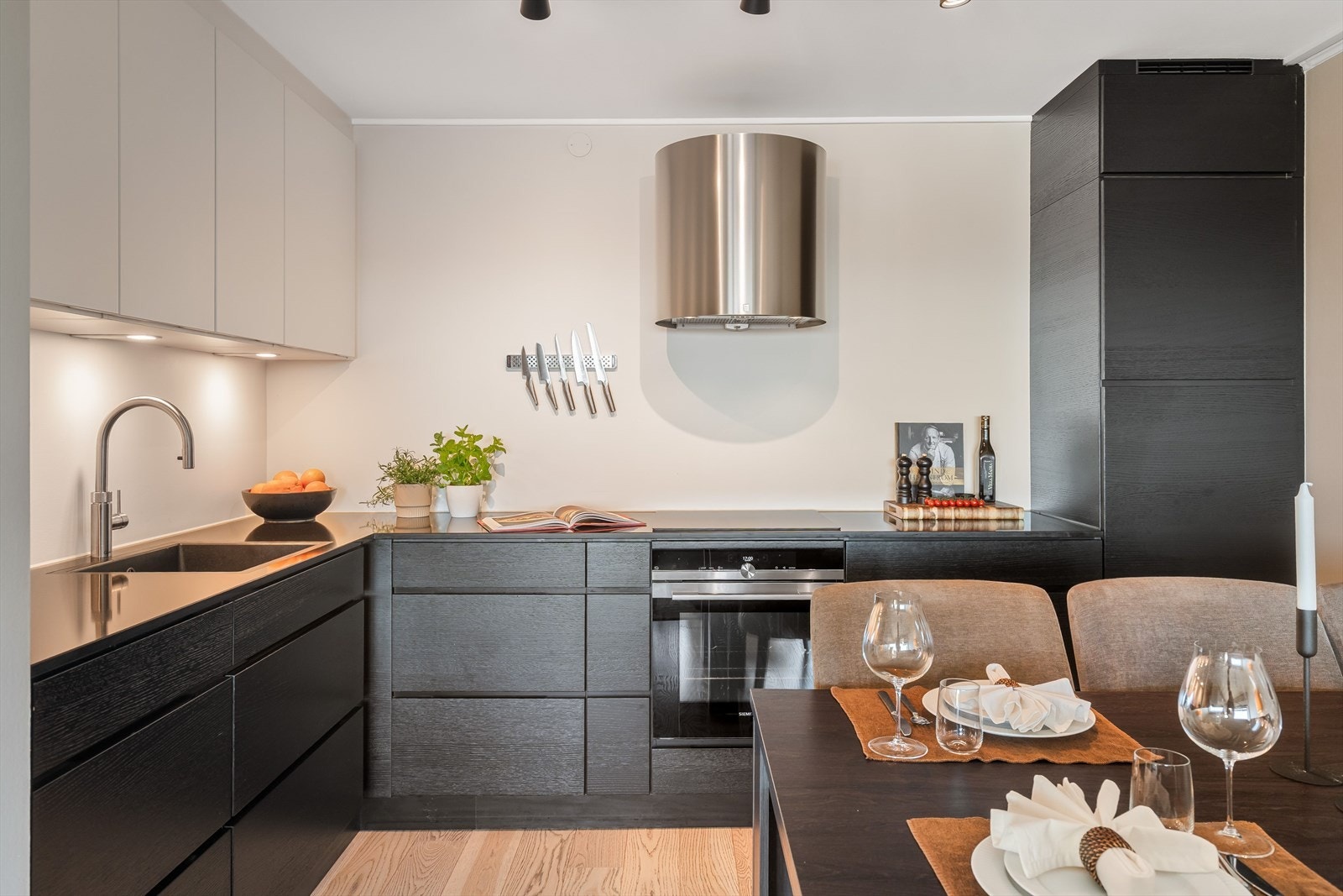 Kvik kjøkkeninnredning med eksklusiv stein benkeplate, Quooker kran og integrerte hvitevarer. Galleribilde