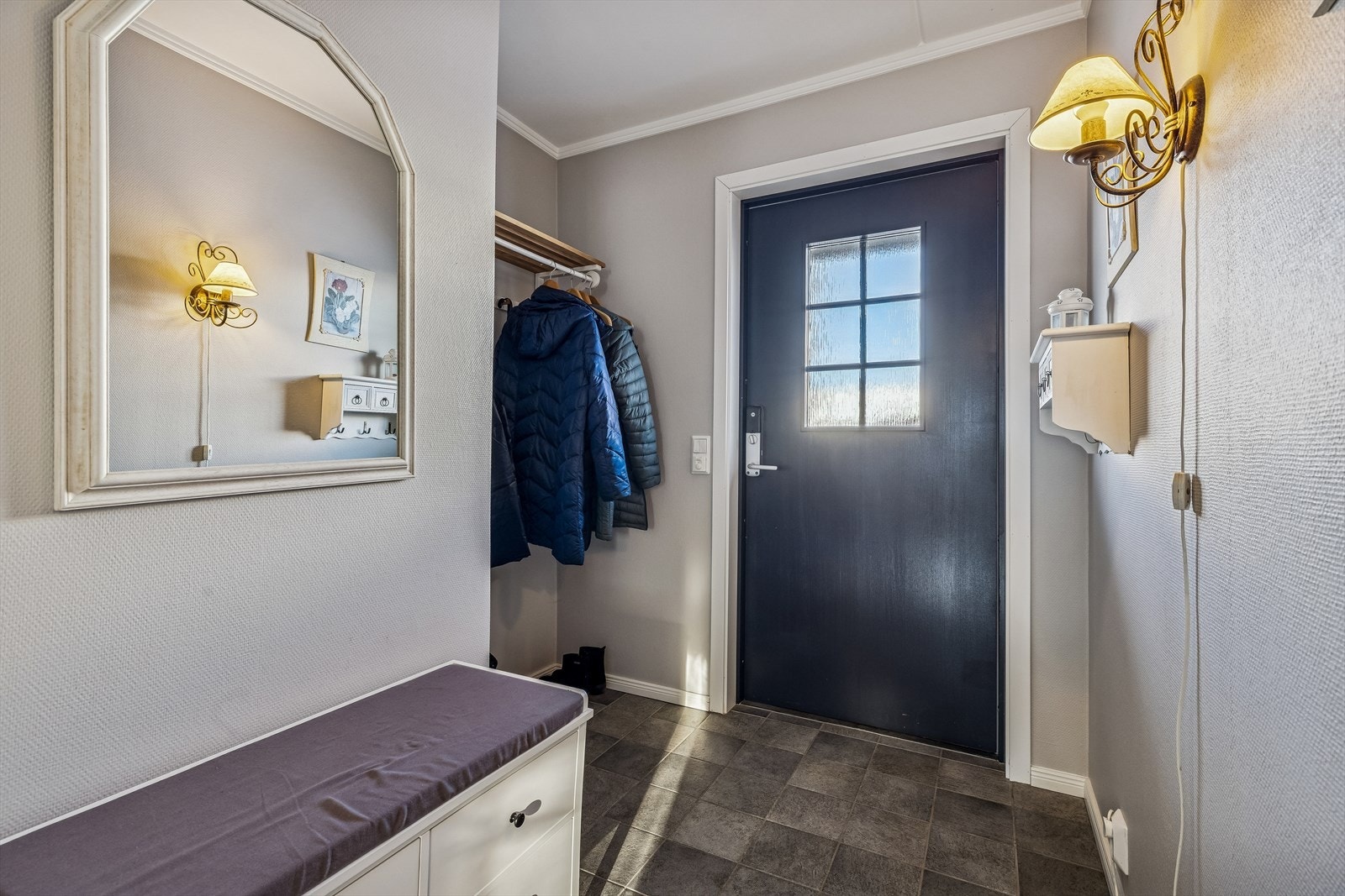Entréen har flislagt gulv og plass til oppbevaring av yttertøy. Galleribilde