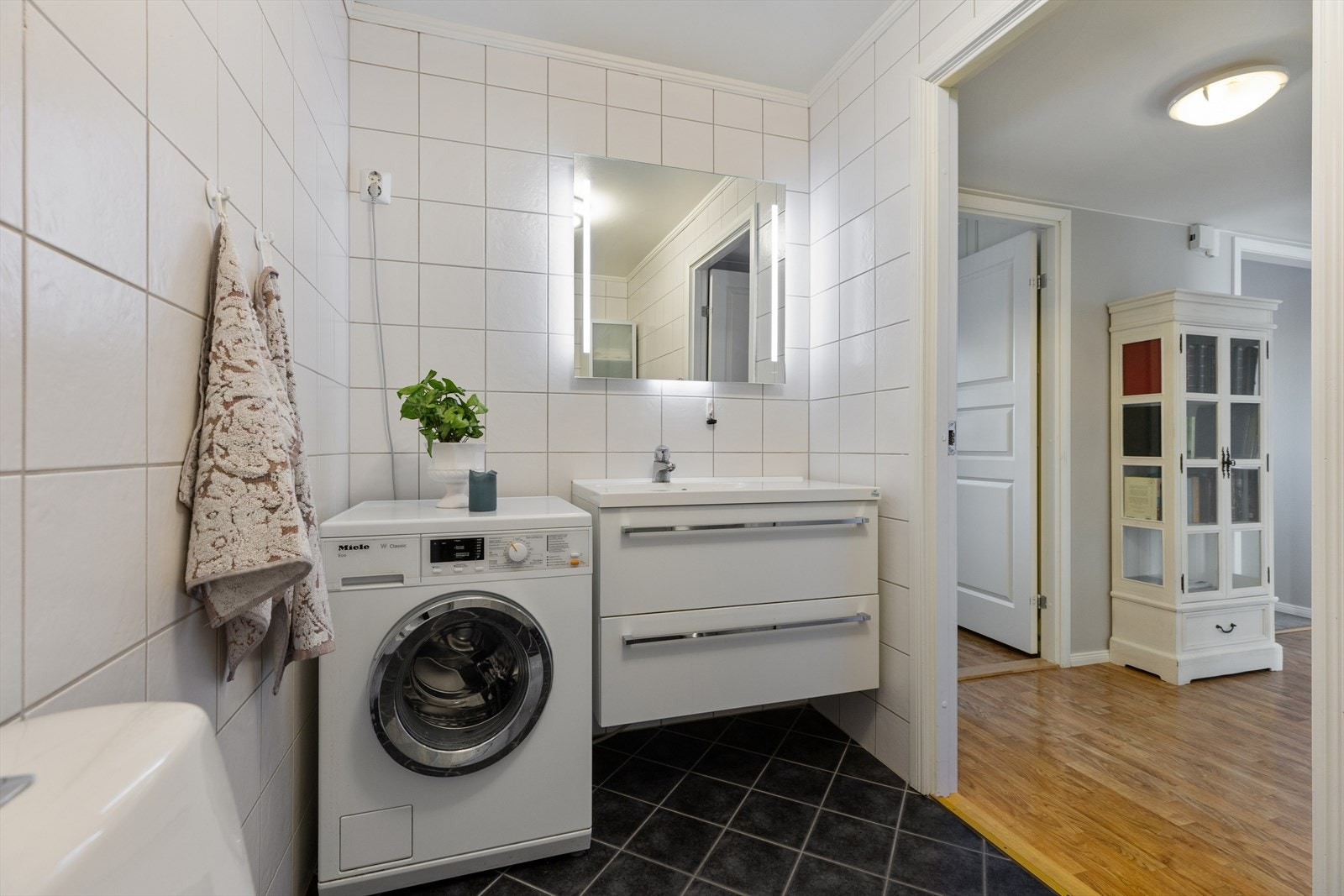 Baderomsinnredning med servantskap for oppbevaring og speil med integrert belysning. Galleribilde