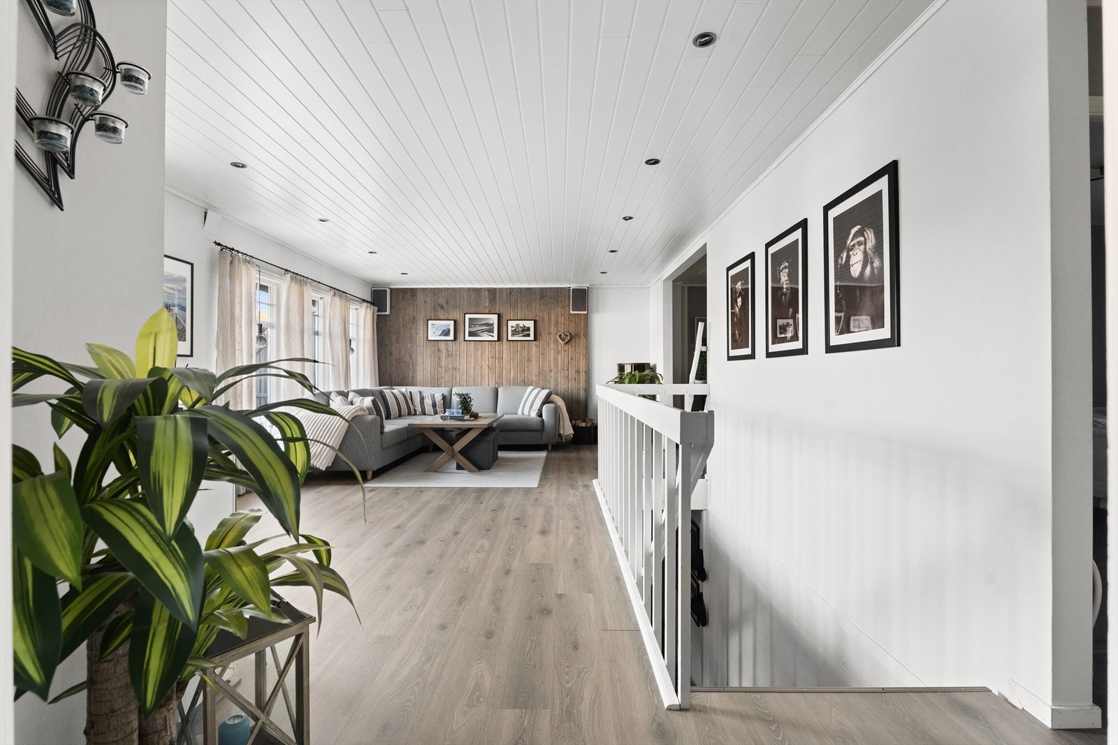 En fondvegg i trepanel gir stuen en varm og særpreget karakter. Galleribilde