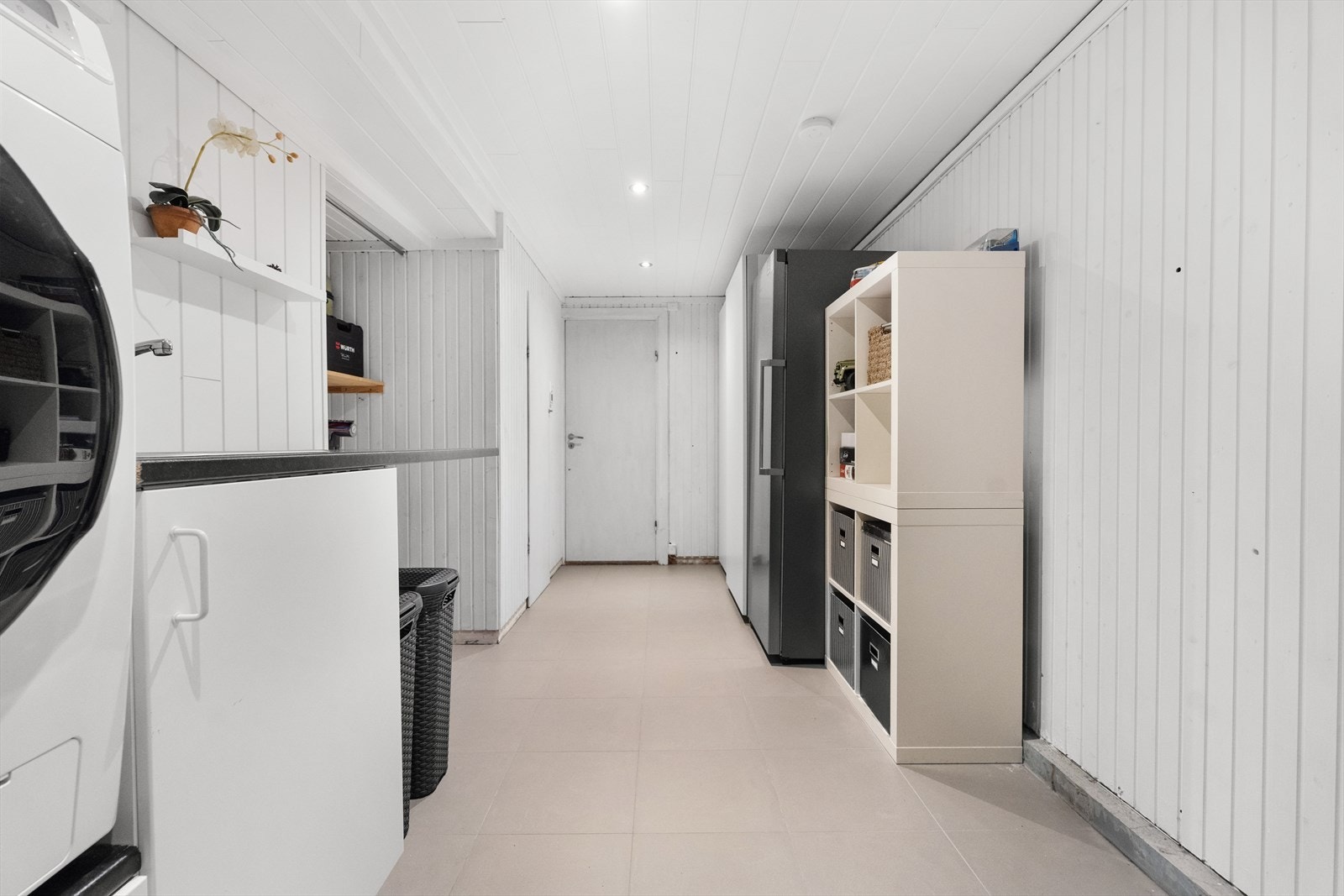 Praktisk og romslig vaskerom med god plass til vaskemaskin, tørketrommel og oppbevaring. Galleribilde