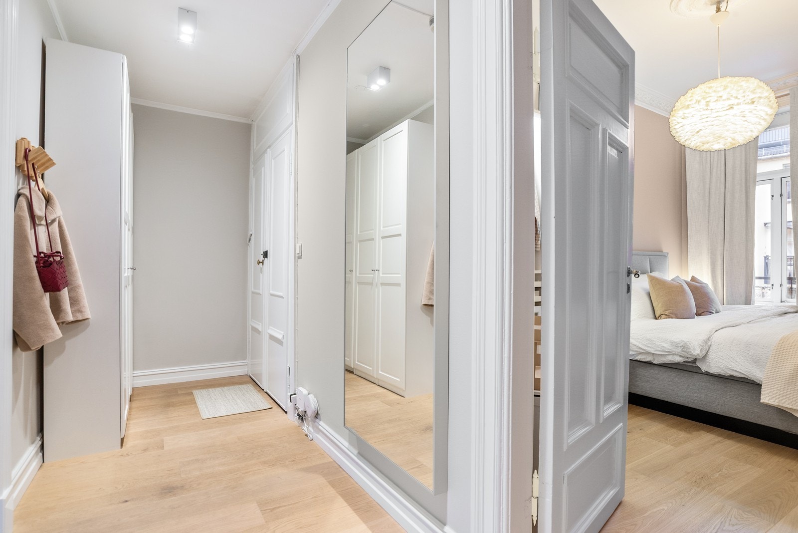 Innbydende entré som deler opp boligens øvrige rom. God plass til oppbevaring av sko og yttertøy i praktisk garderobeskap Galleribilde