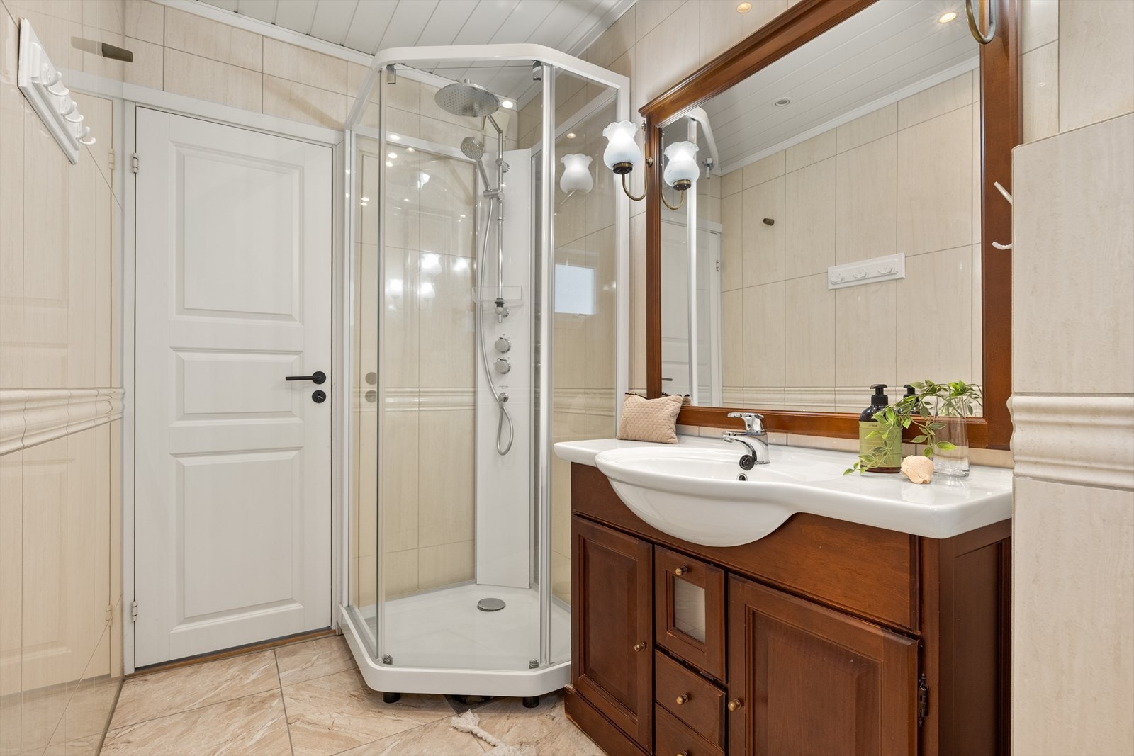 innredet med veggmontert toalett, helstøpt servant i profilert baderomsinnredning og dusjkabinett Galleribilde