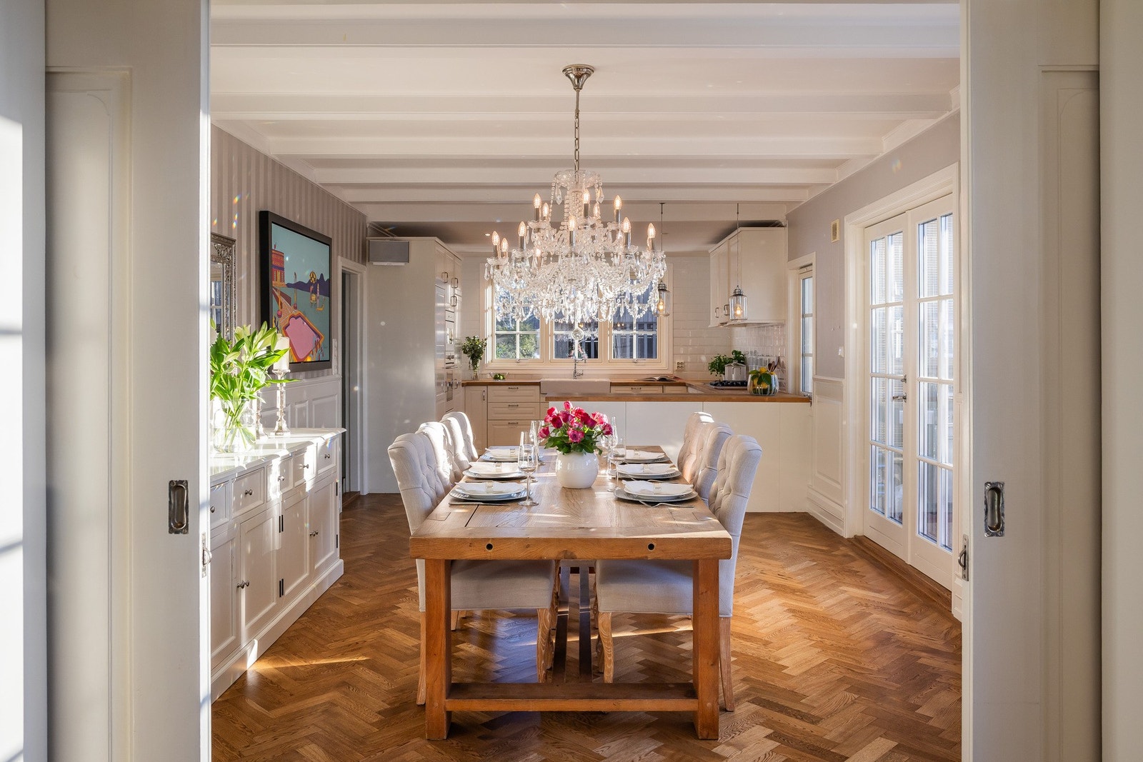 Doble skyvedører leder inn til en lys og åpen spisestue med tilknyttet kjøkken. Galleribilde