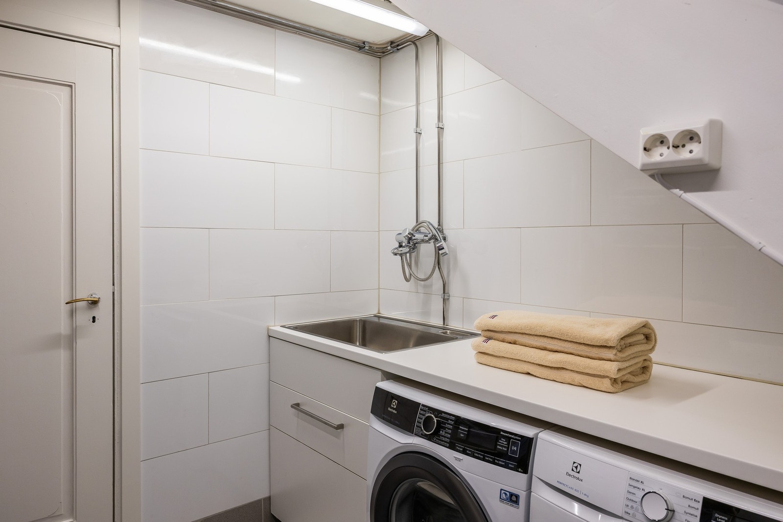 Funksjonelt og praktisk vaskerom med opplegg for både vaskemaskin og tørketrommel. Galleribilde