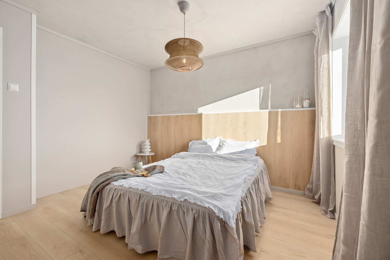 Langs den ene veggen er det laget en fin, plassbygd sengegavl kledd i laminatgulv. Galleribilde