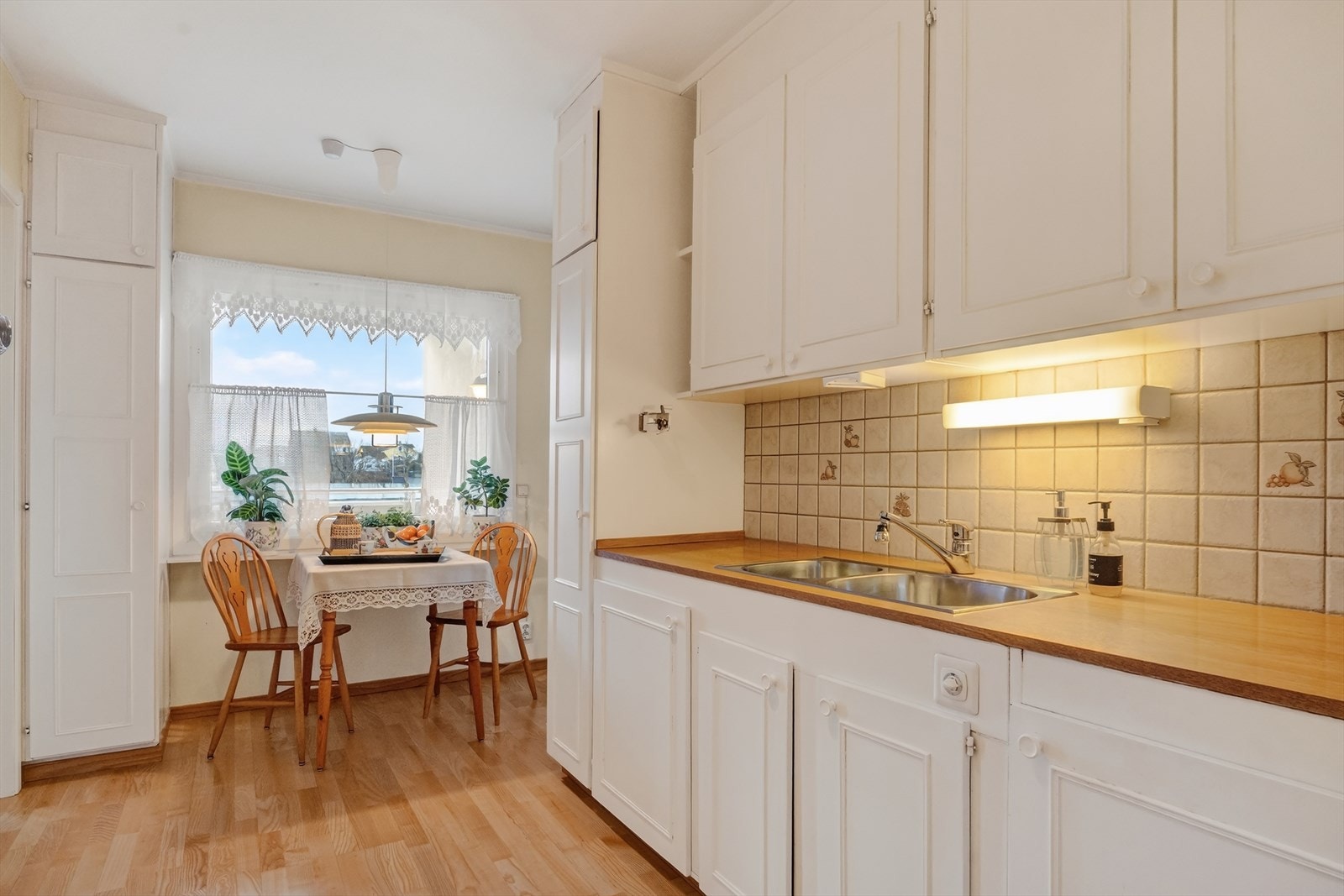 Kjøkken har trivelig spiseplass ved vinduet Galleribilde