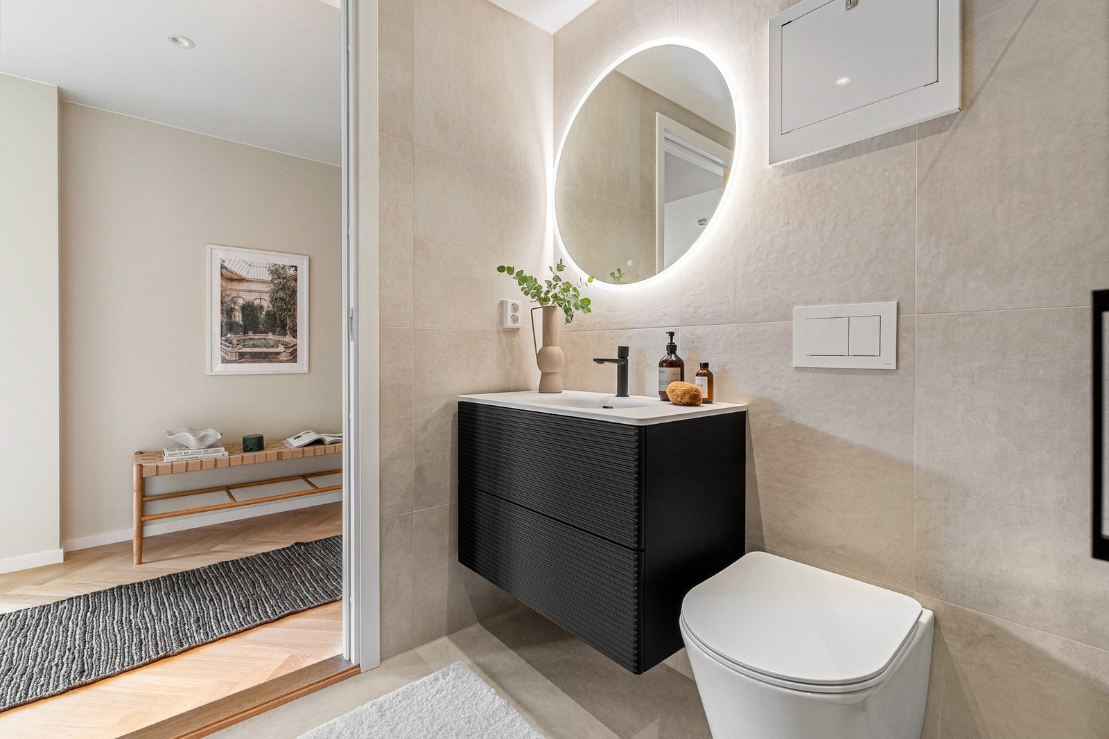 Dusjhjørne med glassvegger og matt sorte armaturer. Vegghengt toalett og skjult sisterne for et rent, moderne uttrykk. Galleribilde