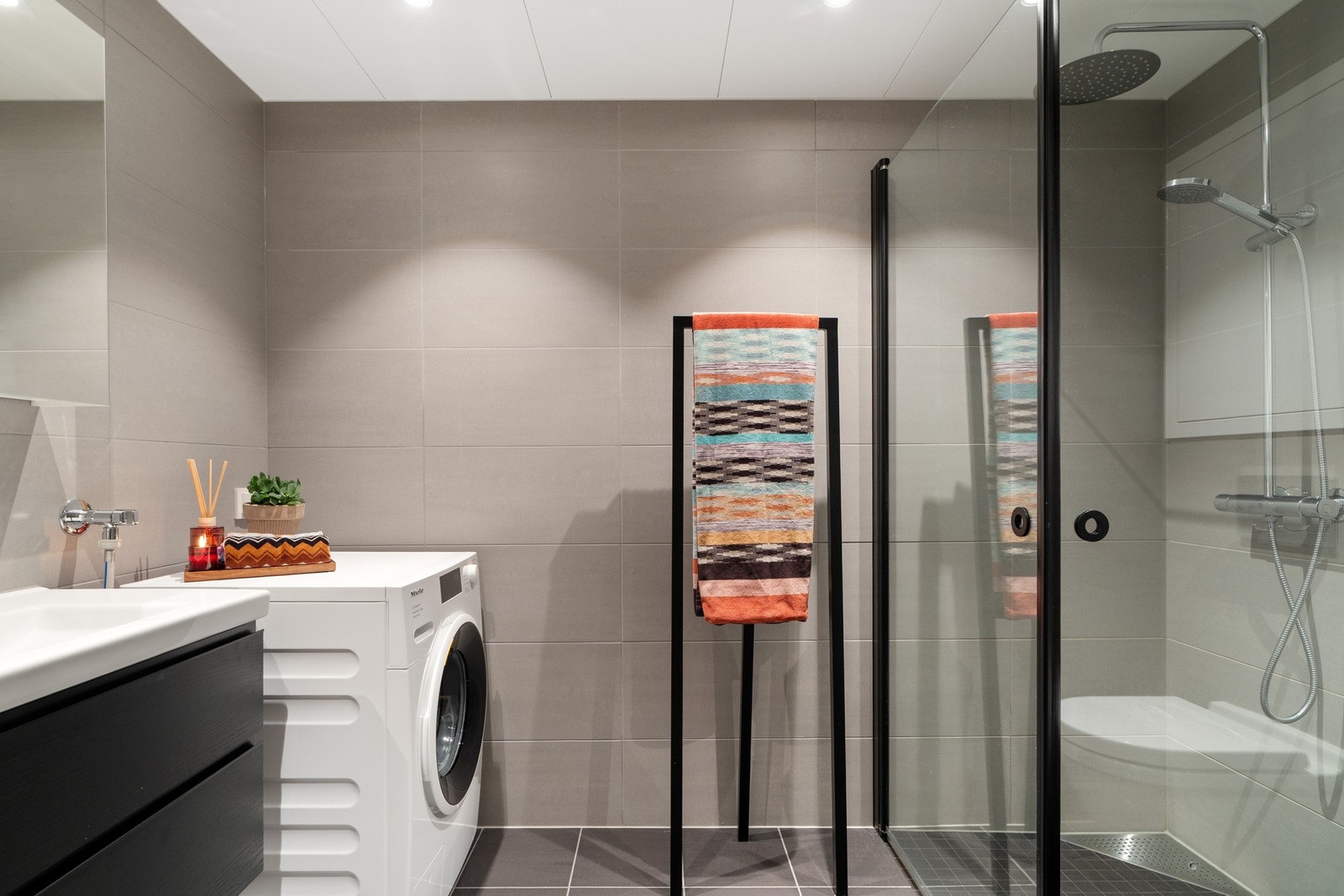 Utstyrt med dusjhjørne med innfellbare vegger, spotter i himling, gulvvarme, opplegg for vaskemaskin, servant og servantskap, speil, og vegghengt wc. Galleribilde