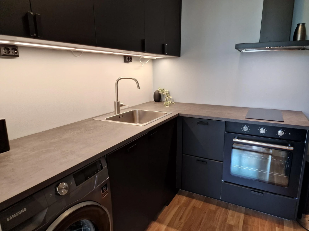 Kjøkken med oppvaskmaskin, stekeovn, kjøleskap, kokeutstyr og mye skapplass Galleribilde