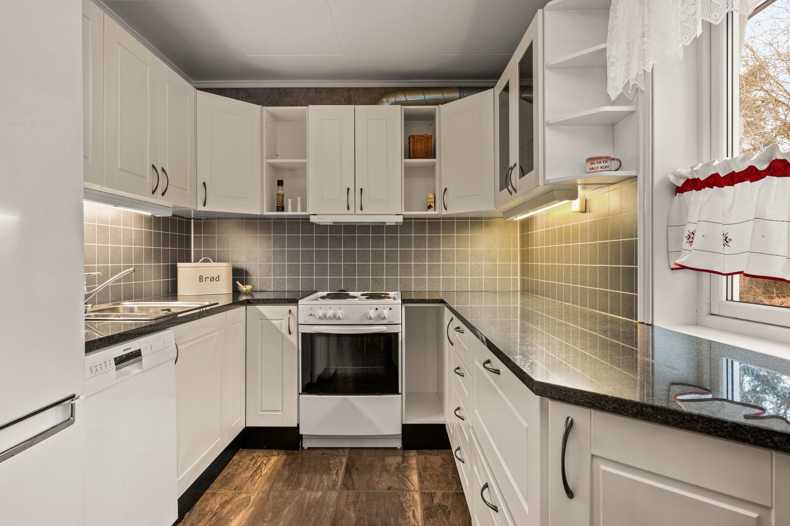 Enkelt kjøkken med god skap- og benkplass Galleribilde