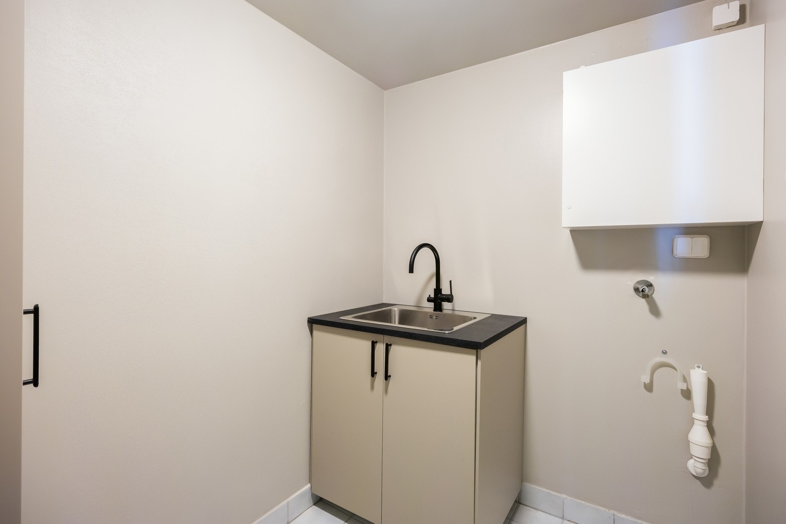 Praktisk vaskerom på 3,8m² med fliser på gulv. Galleribilde