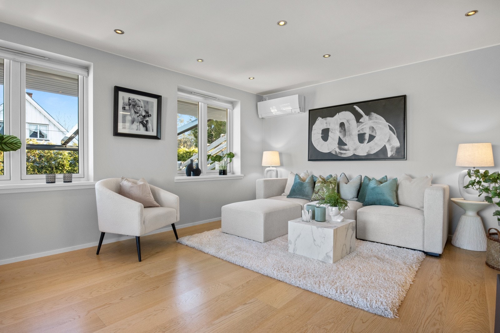 I stuen er veggene malt i en dus gråtone som står godt til parkettgulvet. Det er listfrie overganger til hvit himling med downlights. Galleribilde