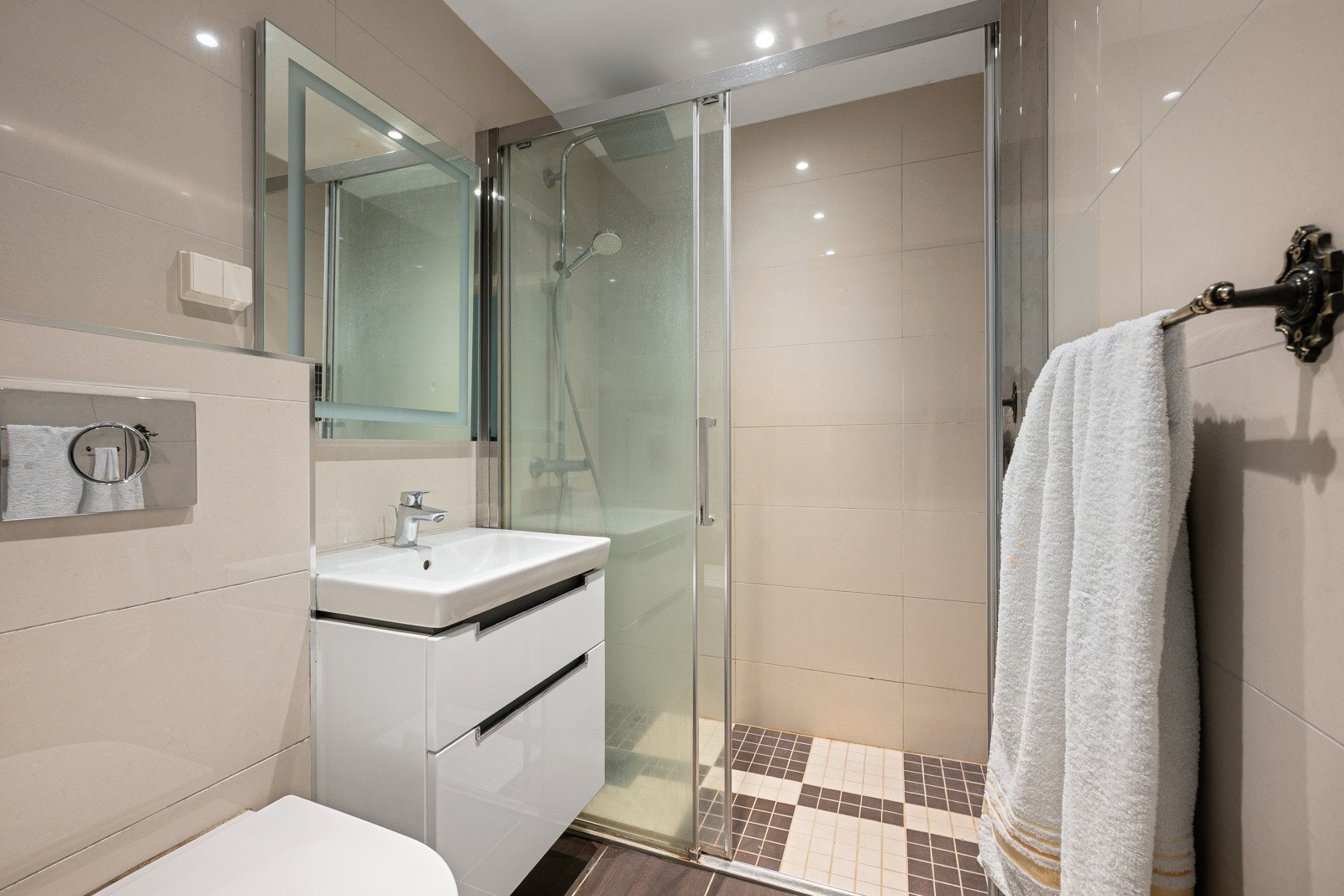 Boligens andre bad, som også ble oppusset i 2017, har innredning med nedfelt servant med underskuffer, vegghengt toalett og dusjhjørne med glassvegger. Galleribilde